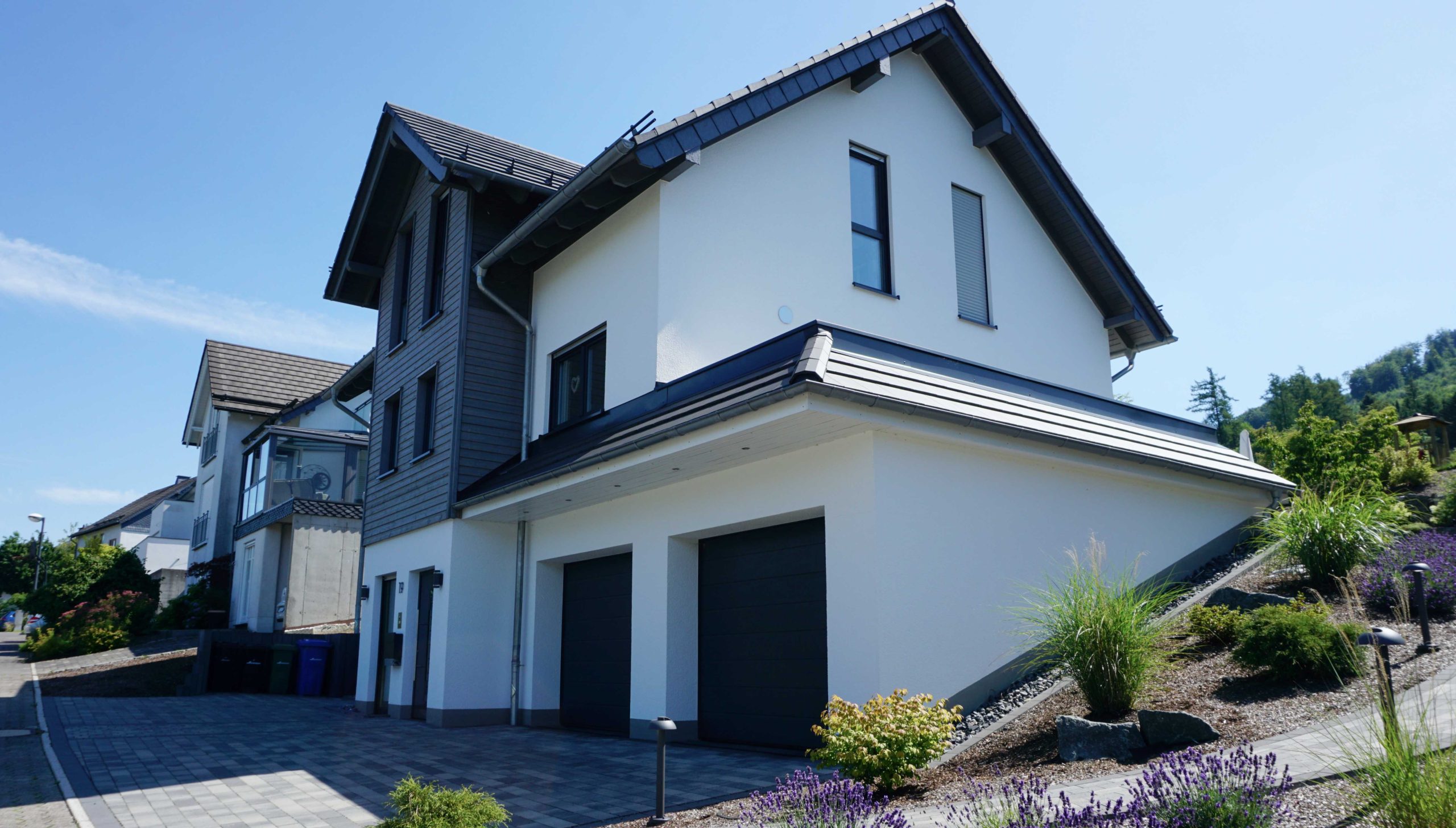 Außenansicht des Einfamilienhauses mit Hanglage, Doppelgarage und Erker