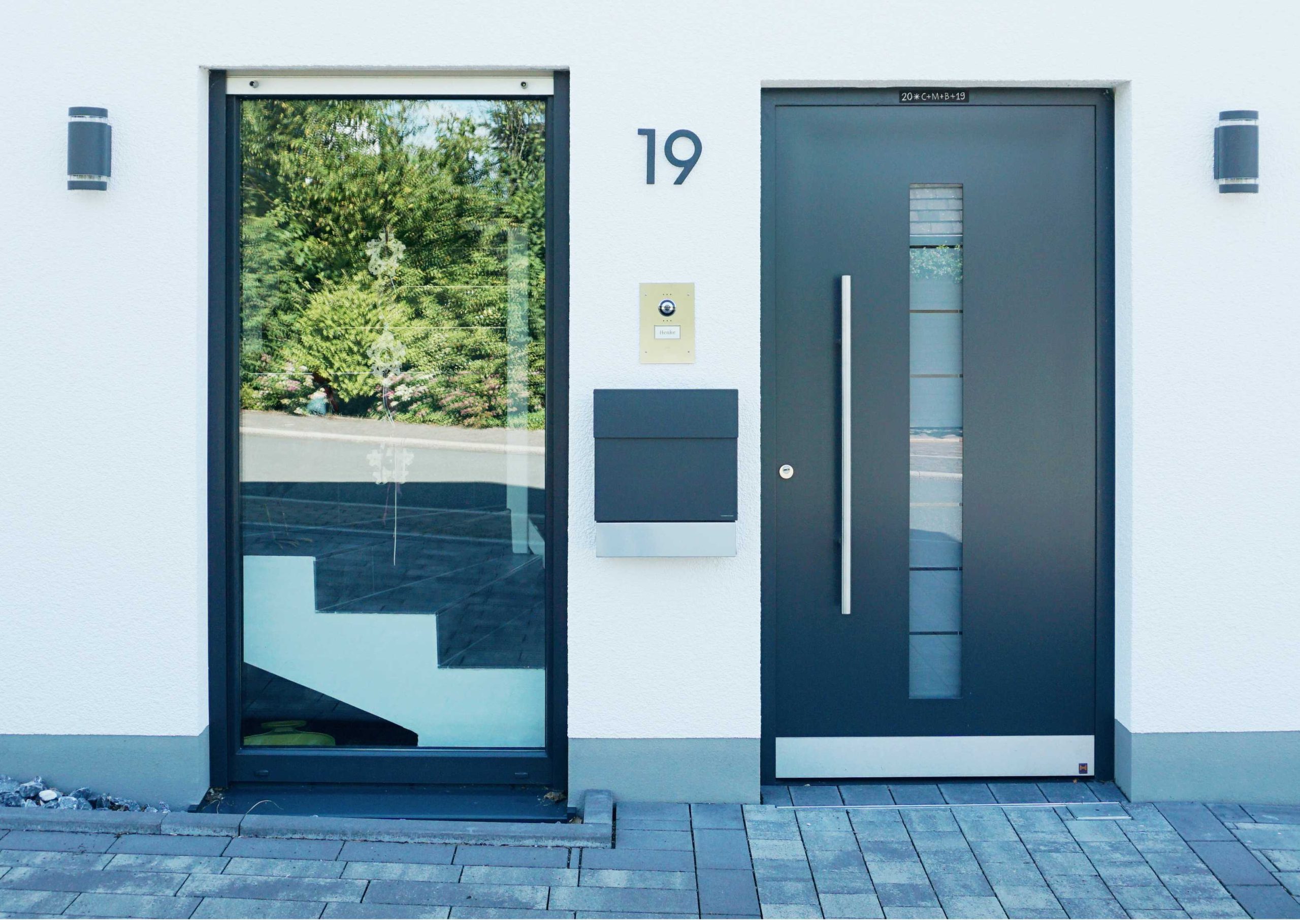 Detailaufnahme des modernen Hauseingangs mit Glasseitenteil, Haustür und Hausnummer 19