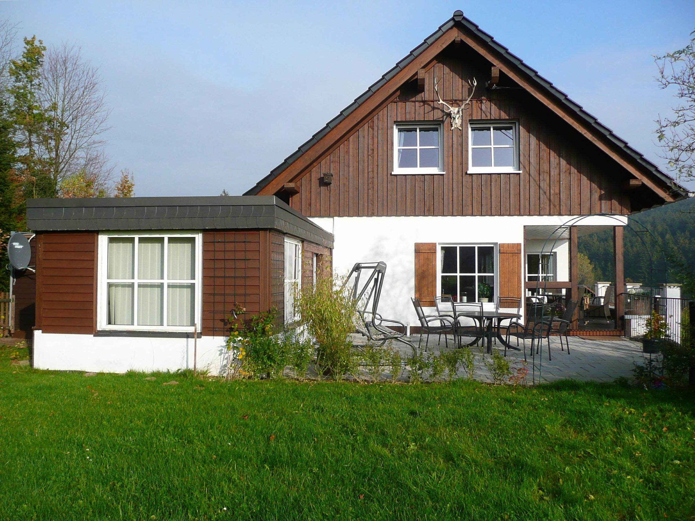 Gartenseitige Ansicht eines Ferienhauses mit Holzfassade und Terrasse