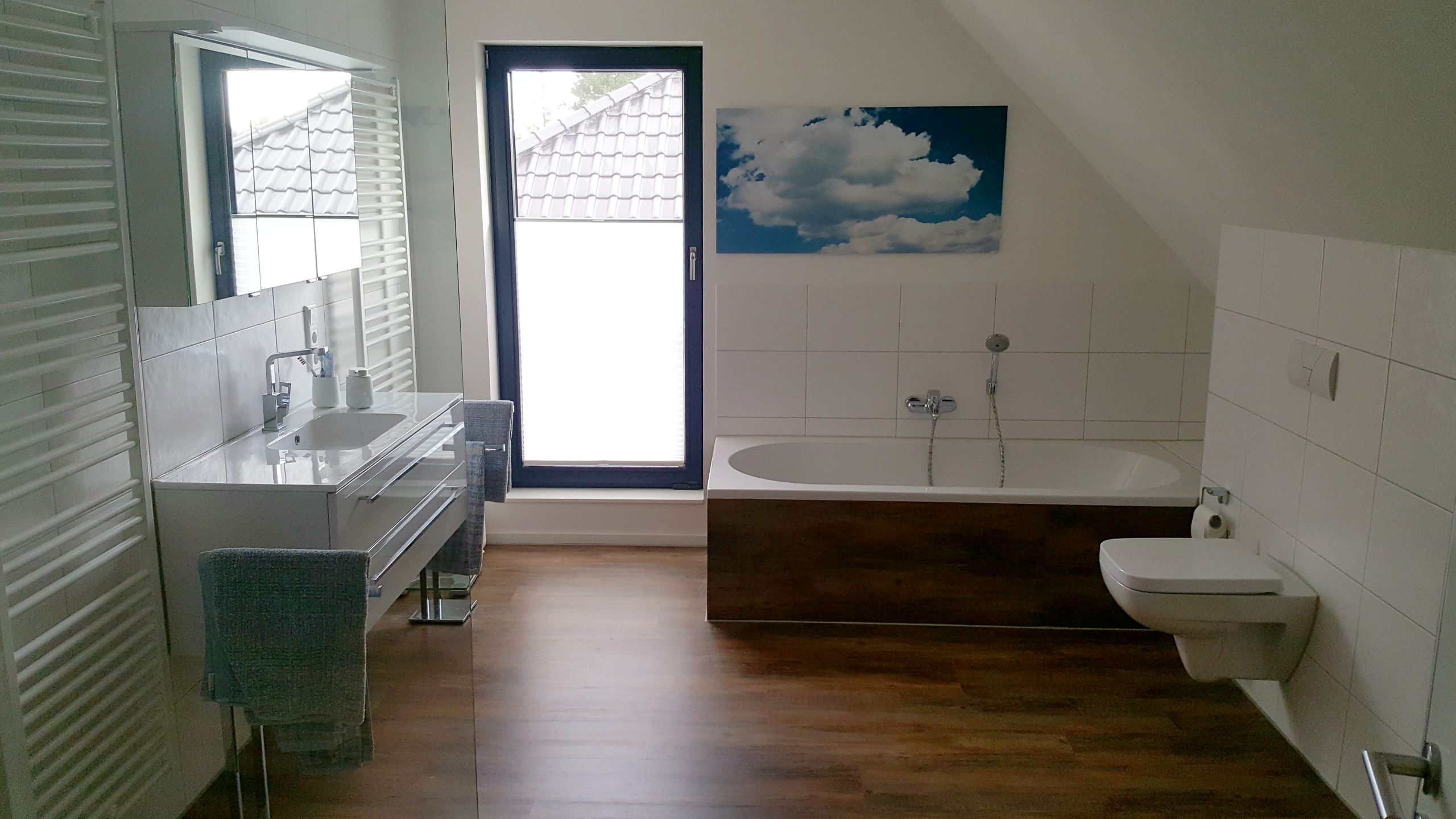 Badezimmer im Dachgeschoss mit Badewanne, Waschtisch, Fenster und Dachschräge