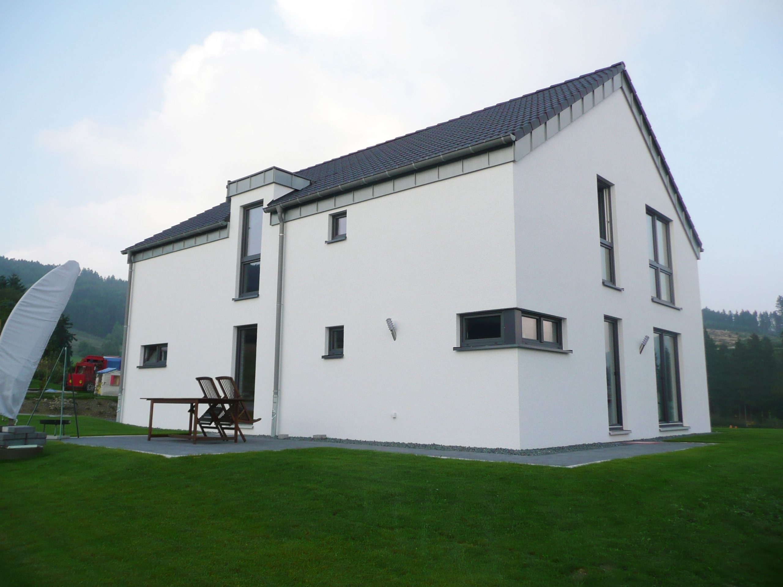 Rückwärtige Ansicht eines Einfamilienhauses mit weißem Außenputz