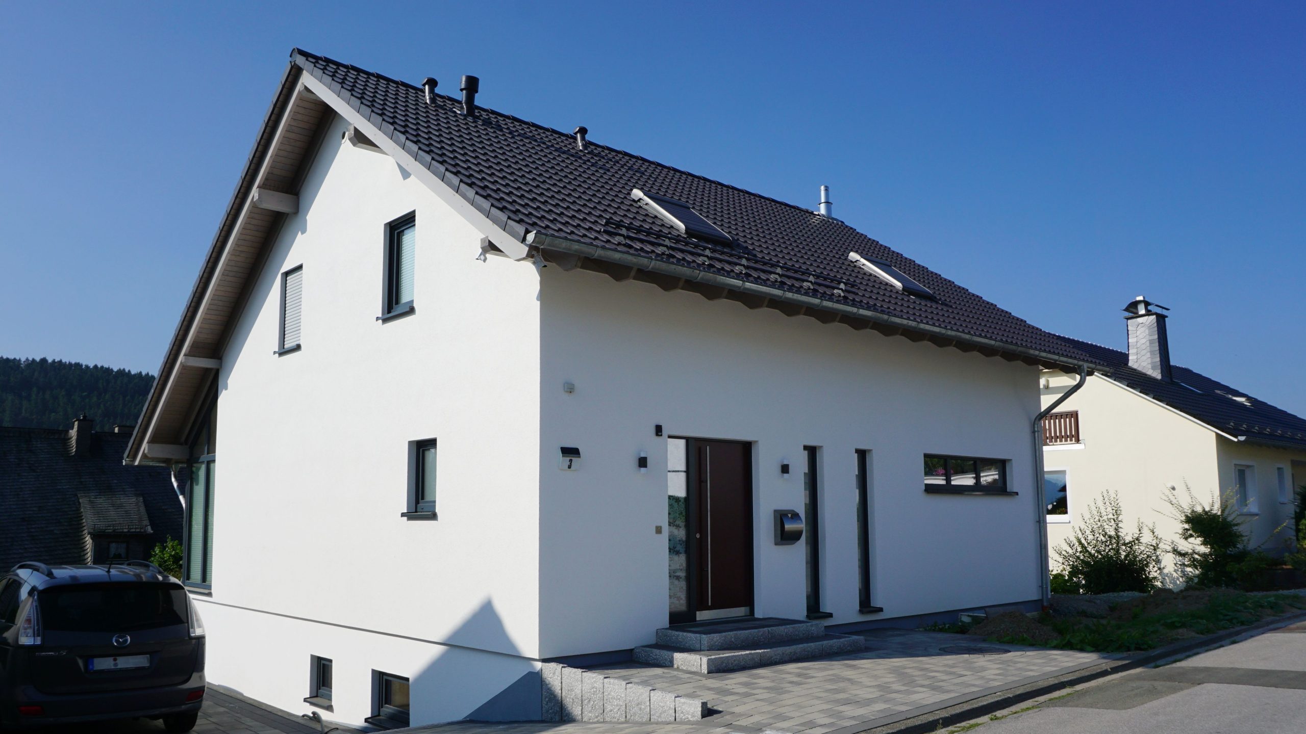 Straßenansicht des Einfamilienhauses mit Satteldach und Zugangsebene