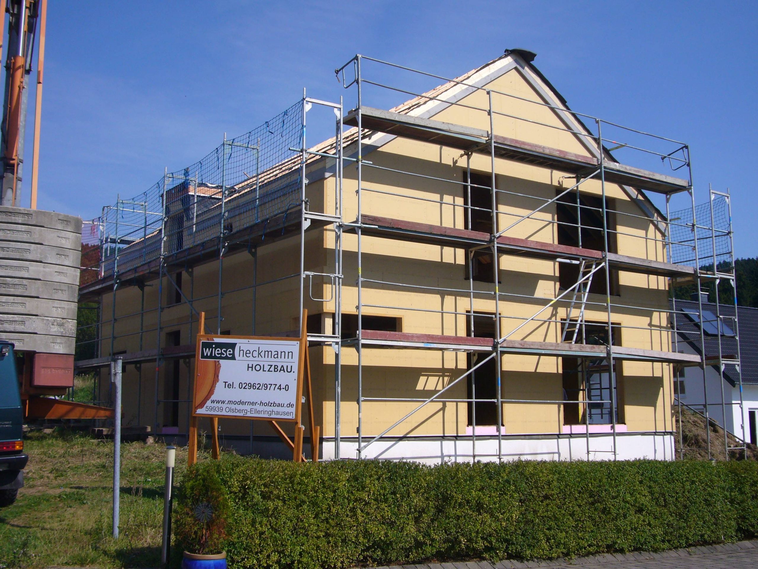 Holzrahmenbau eines Einfamilienhauses während der Bauphase mit Gerüst