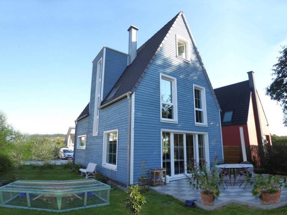 Nordisch gestaltetes Holzhaus mit Terrasse und Gartenbereich