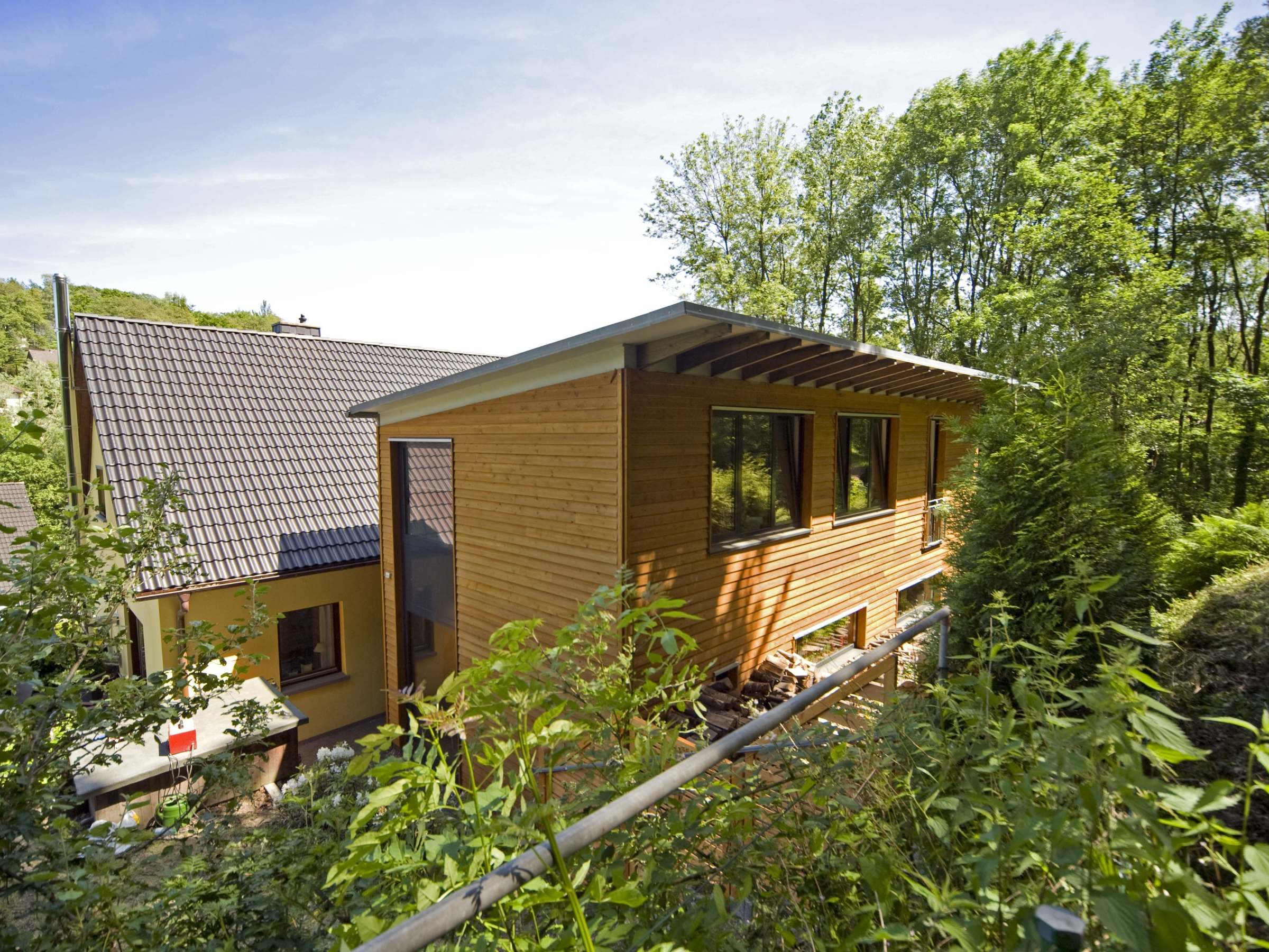 Gartenseitige Ansicht des zweigeschossigen Anbaus mit Holzfassade