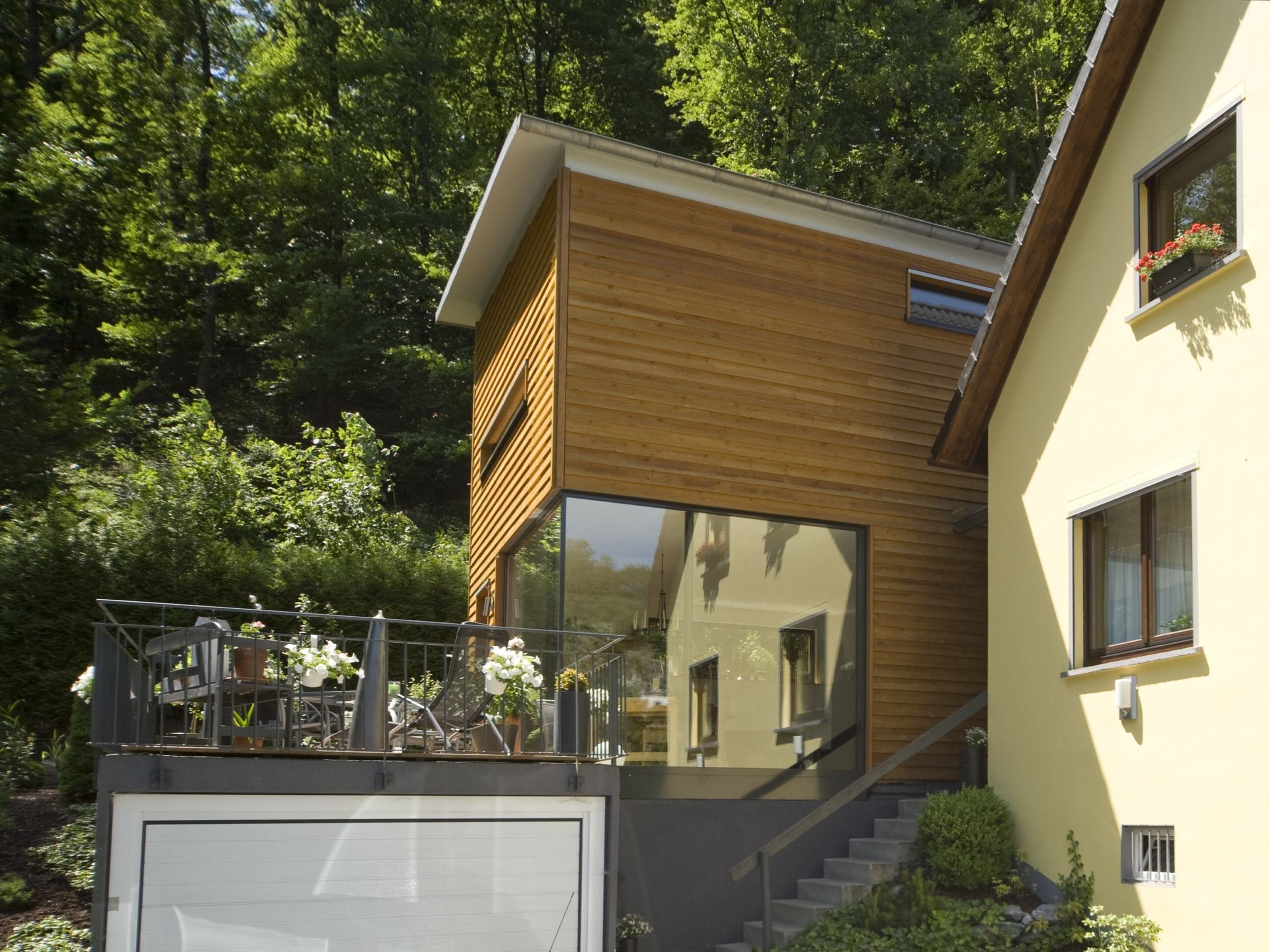 Seitenansicht des zweigeschossigen Holzanbaus mit klarer Kubatur
