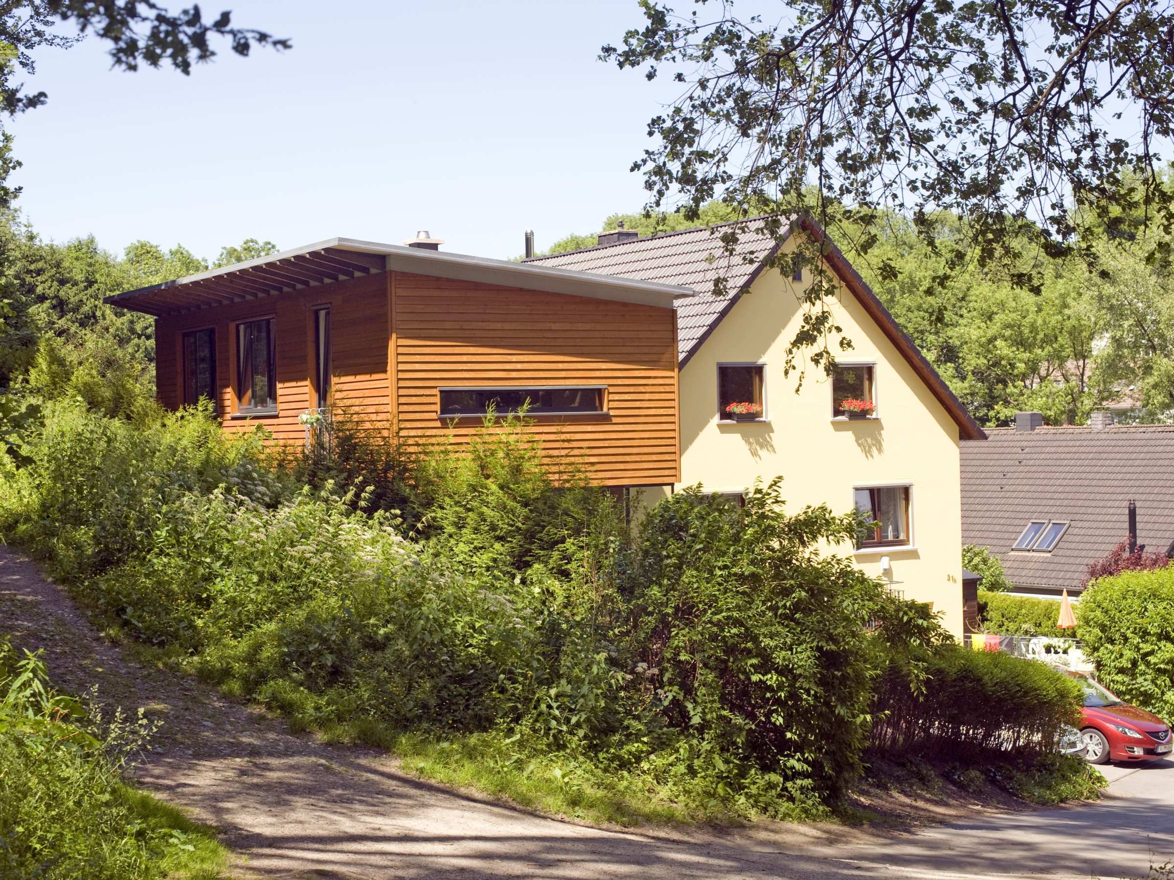 Detailansicht der horizontalen Holzfassade des Anbaus neben Bestandsgebäude