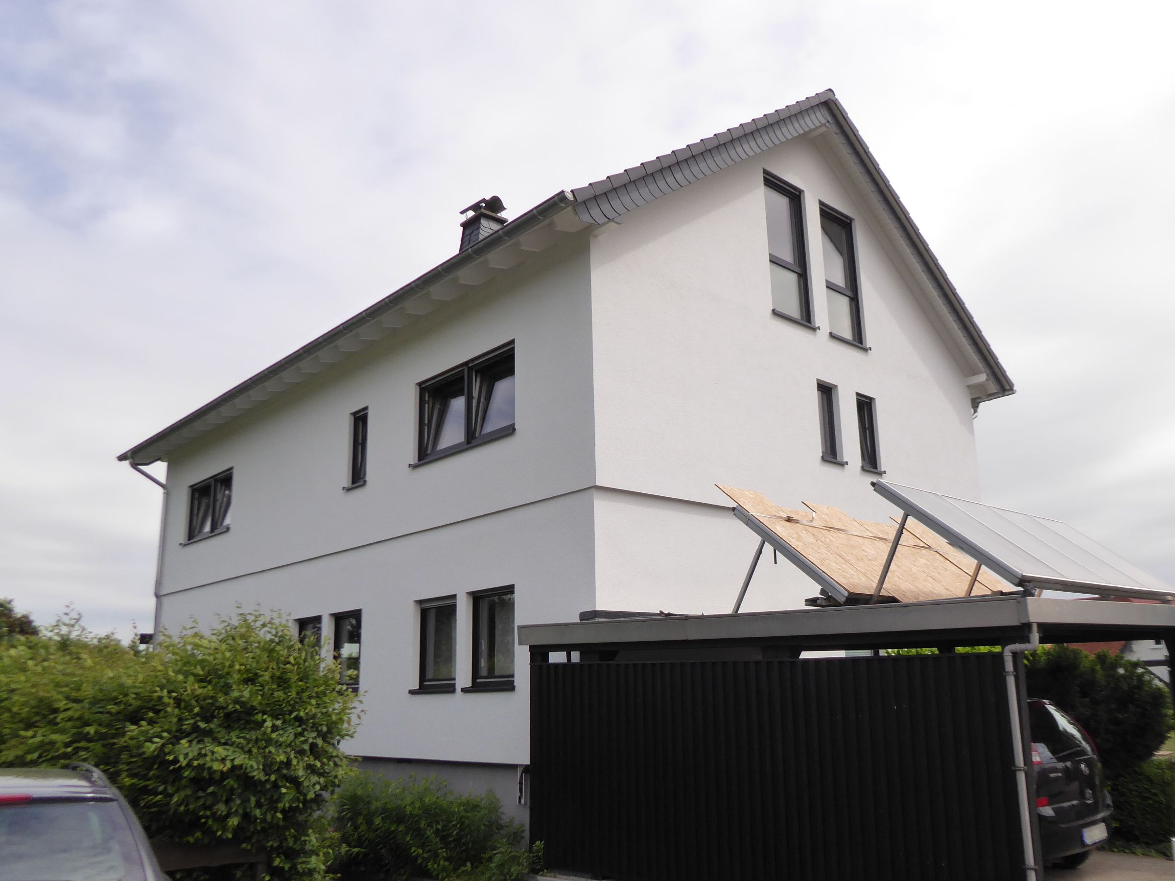 Seitenansicht des aufgestockten Wohnhauses mit angrenzendem Carport
