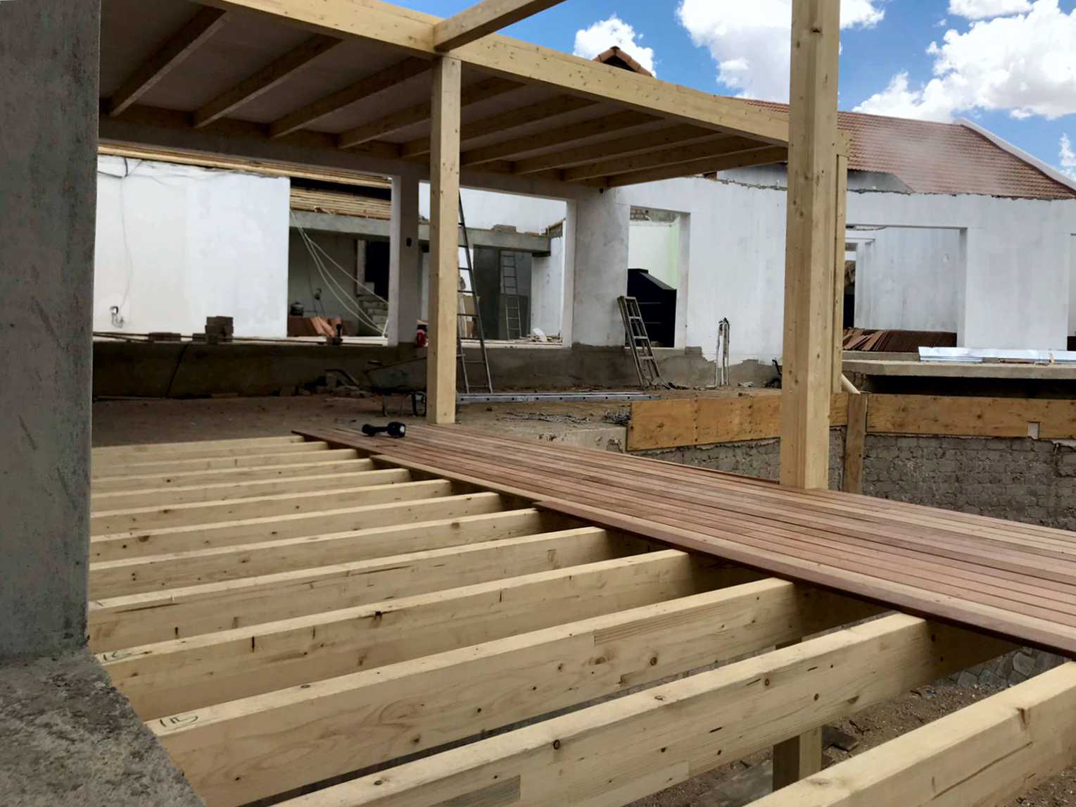Holzrahmenbau mit sichtbaren Deckenbalken während der Bauphase eines Gebäudes in Namibia