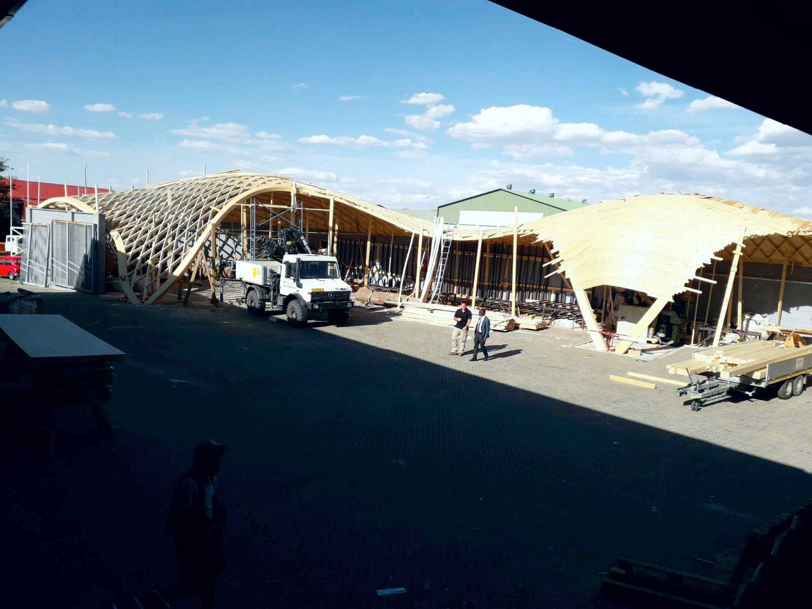 Baustellenübersicht mit großformatigen Holztragwerken und Hallenkonstruktionen aus Holz in Namibia