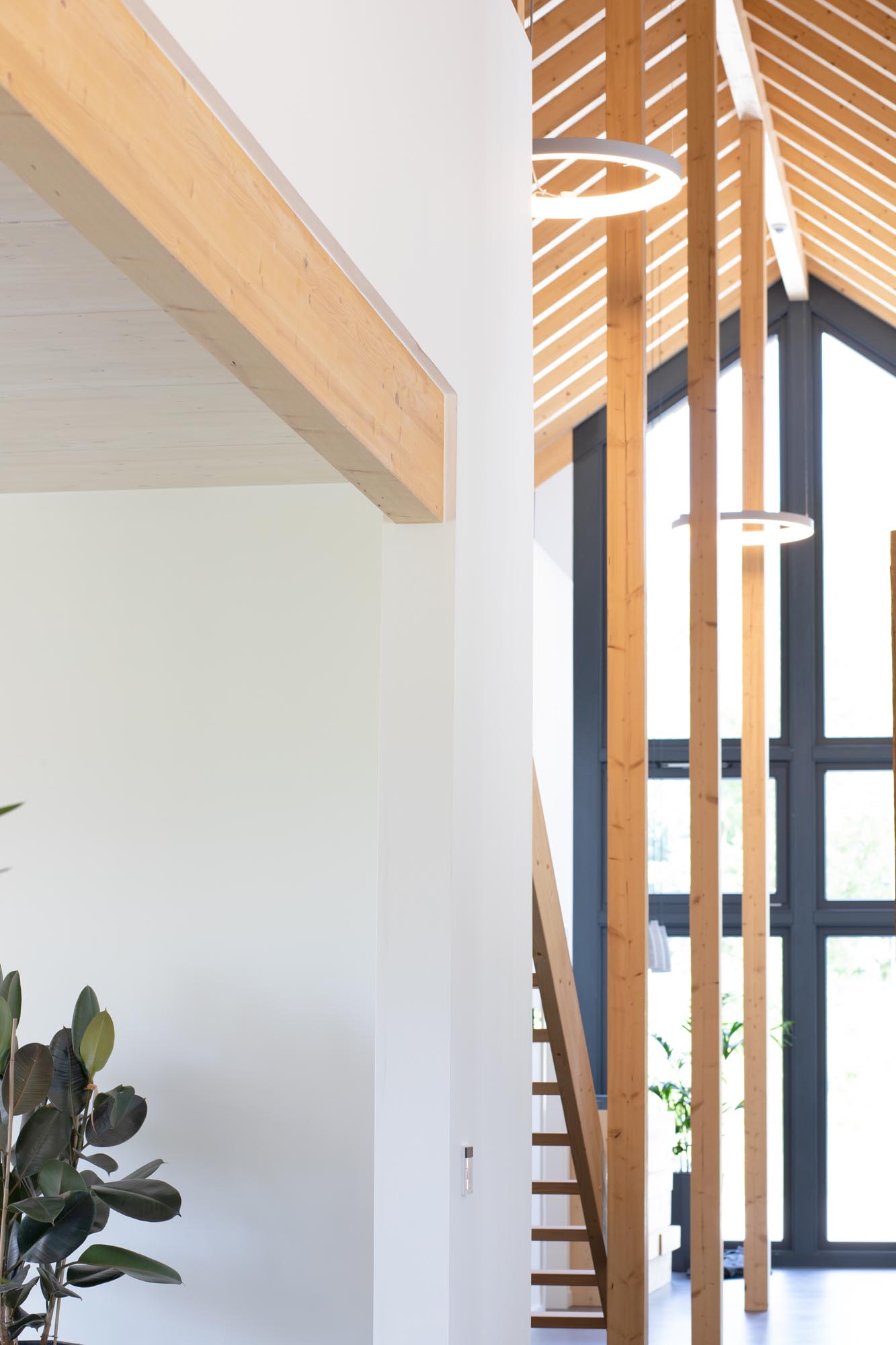 Runde Pendelleuchten vor sichtbarer Holz-Dachkonstruktion in einem modernen Bürogebäude