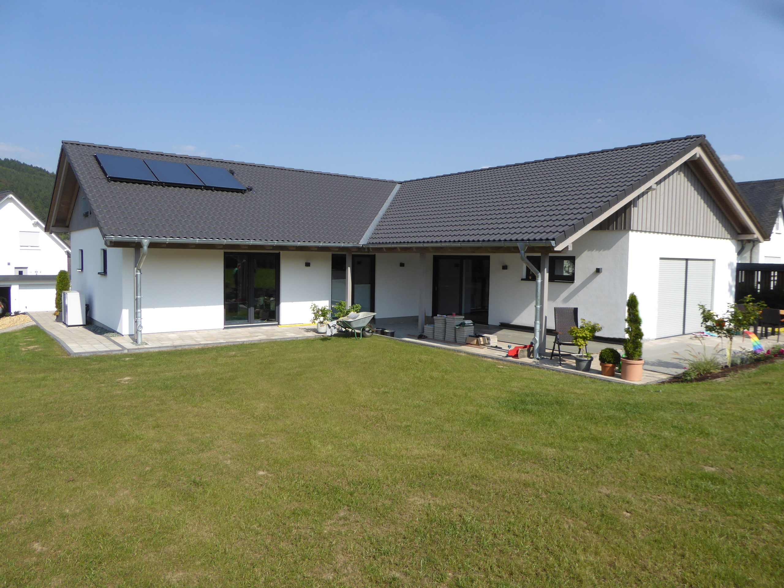 Terrassenansicht des ebenerdigen Bungalows mit erweitertem Dachüberstand zur Verschattung