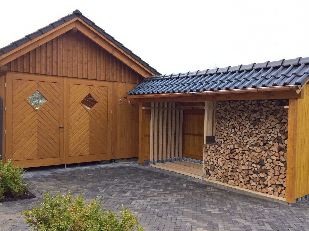 Remise mit vertikaler Holzfassade und integrierter Holzlagerfläche