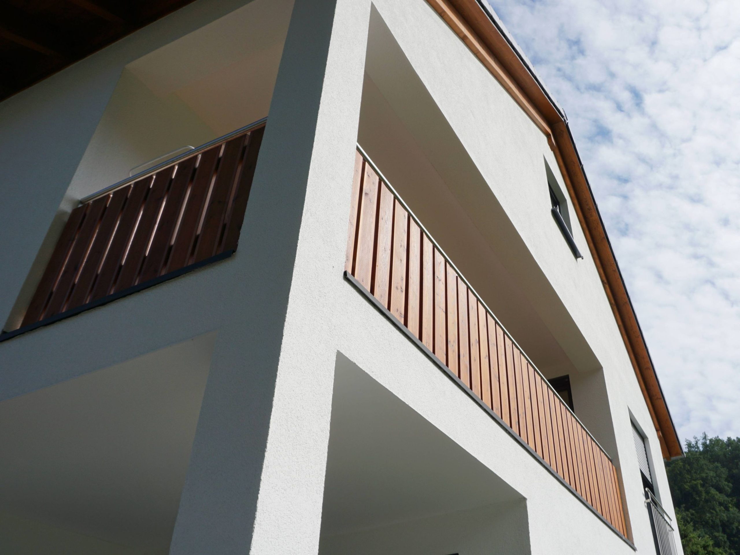 Giebelseite eines Einfamilienhauses mit Balkon und symmetrischer Fassadengliederung