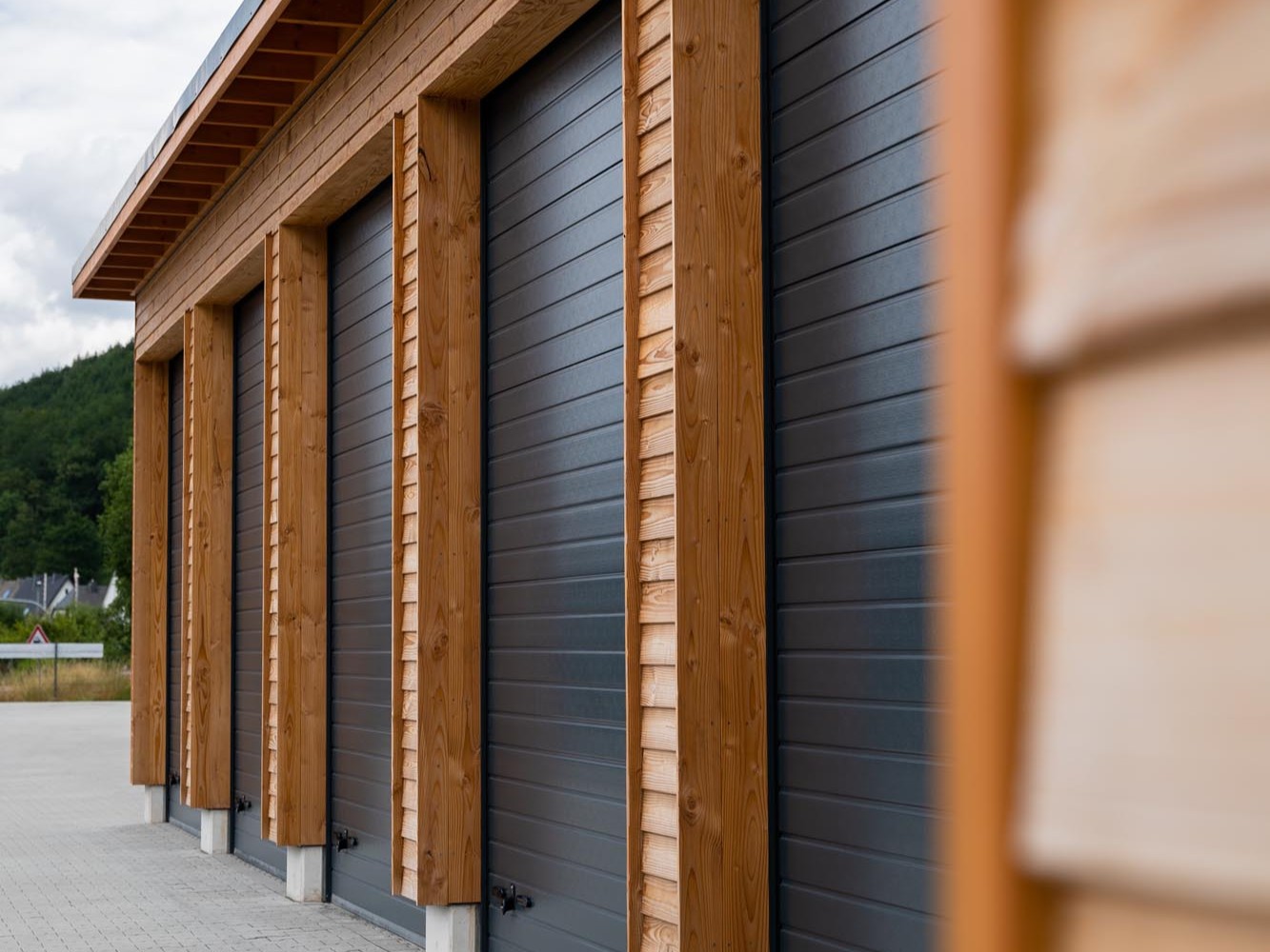 Dachranddetail eines Garagengebäudes mit Holzfassade und klar ausgebildetem Dachüberstand