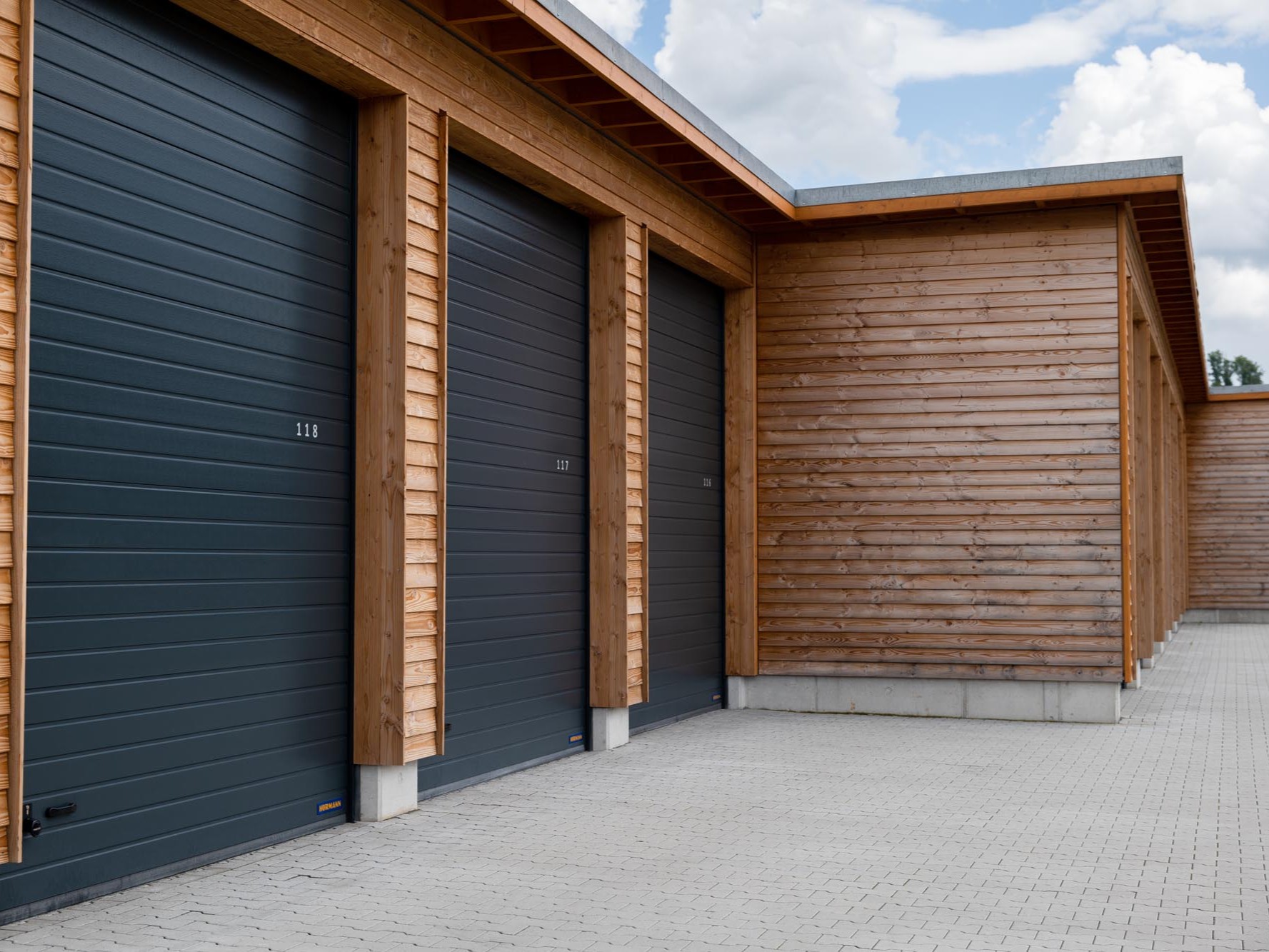 Stirnseitige Ansicht eines Garagengebäudes mit geschlossener Lärchenholzfassade