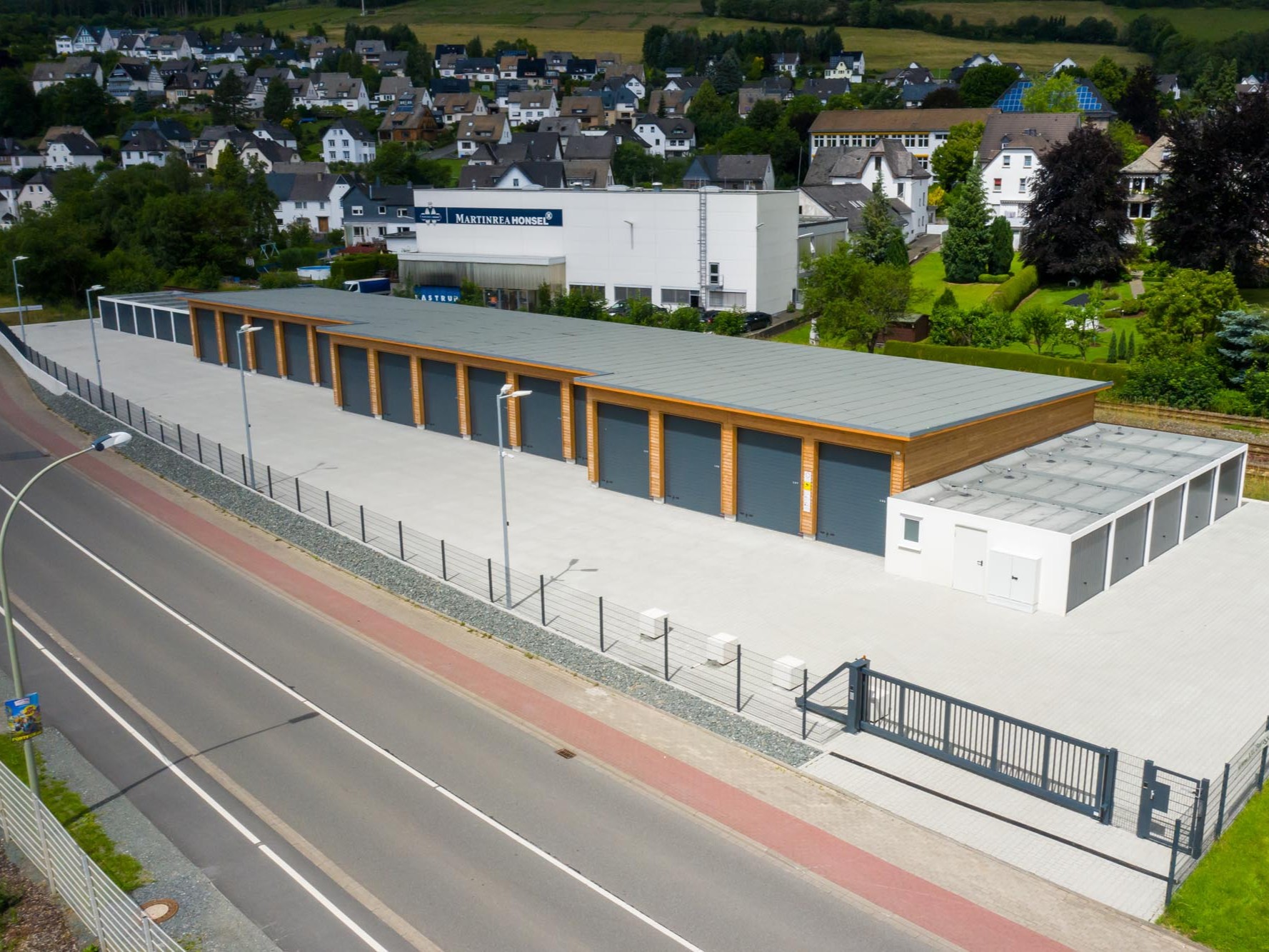 Luftaufnahme einer Garagenanlage mit langgestrecktem Baukörper und Holzfassade in Bestwig