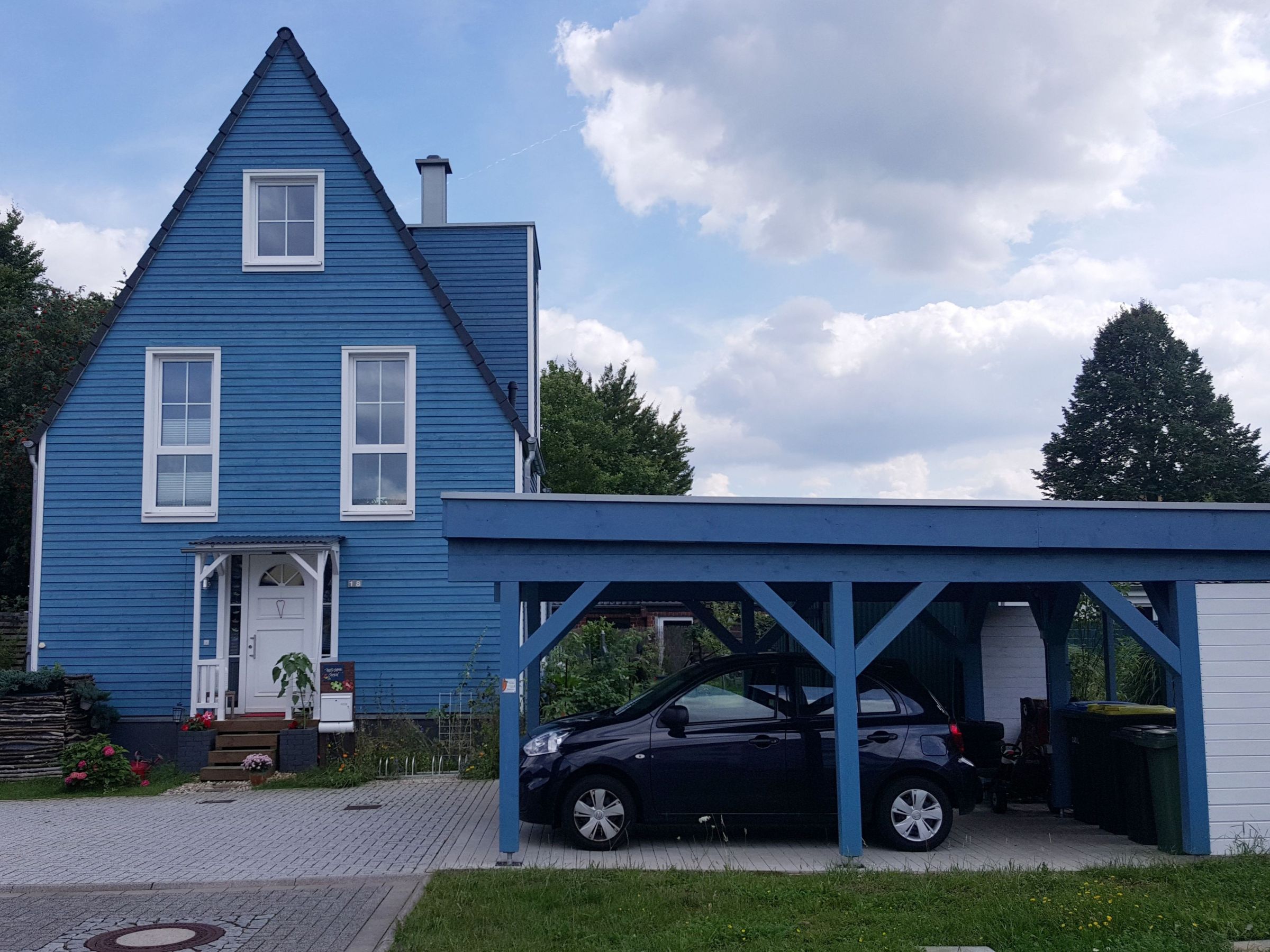 Friesenblaues Einfamilienhaus mit angebautem Carport in Holzbauweise