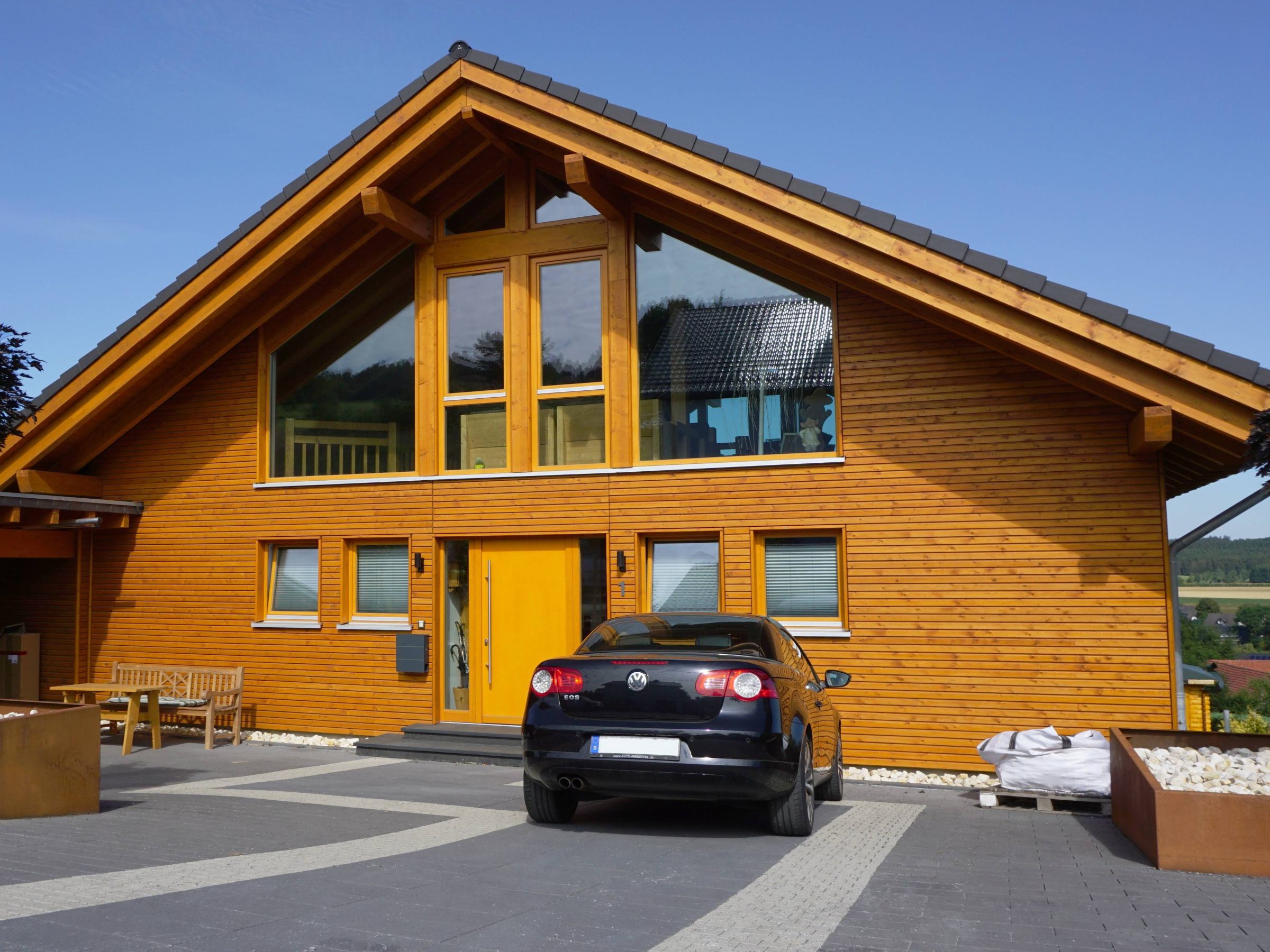 Holzfassade mit mittig angeordnetem Eingangsbereich und Fensteröffnungen