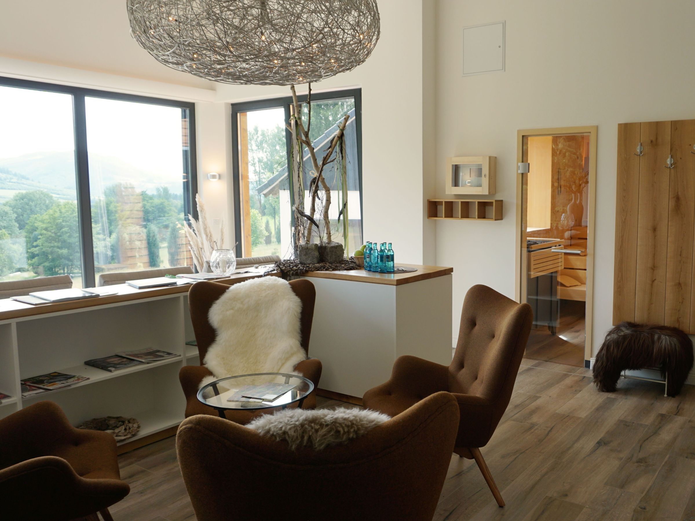 Ruheraum mit Sitzmöbeln, Holzoberflächen und Blick in die umliegende Landschaft