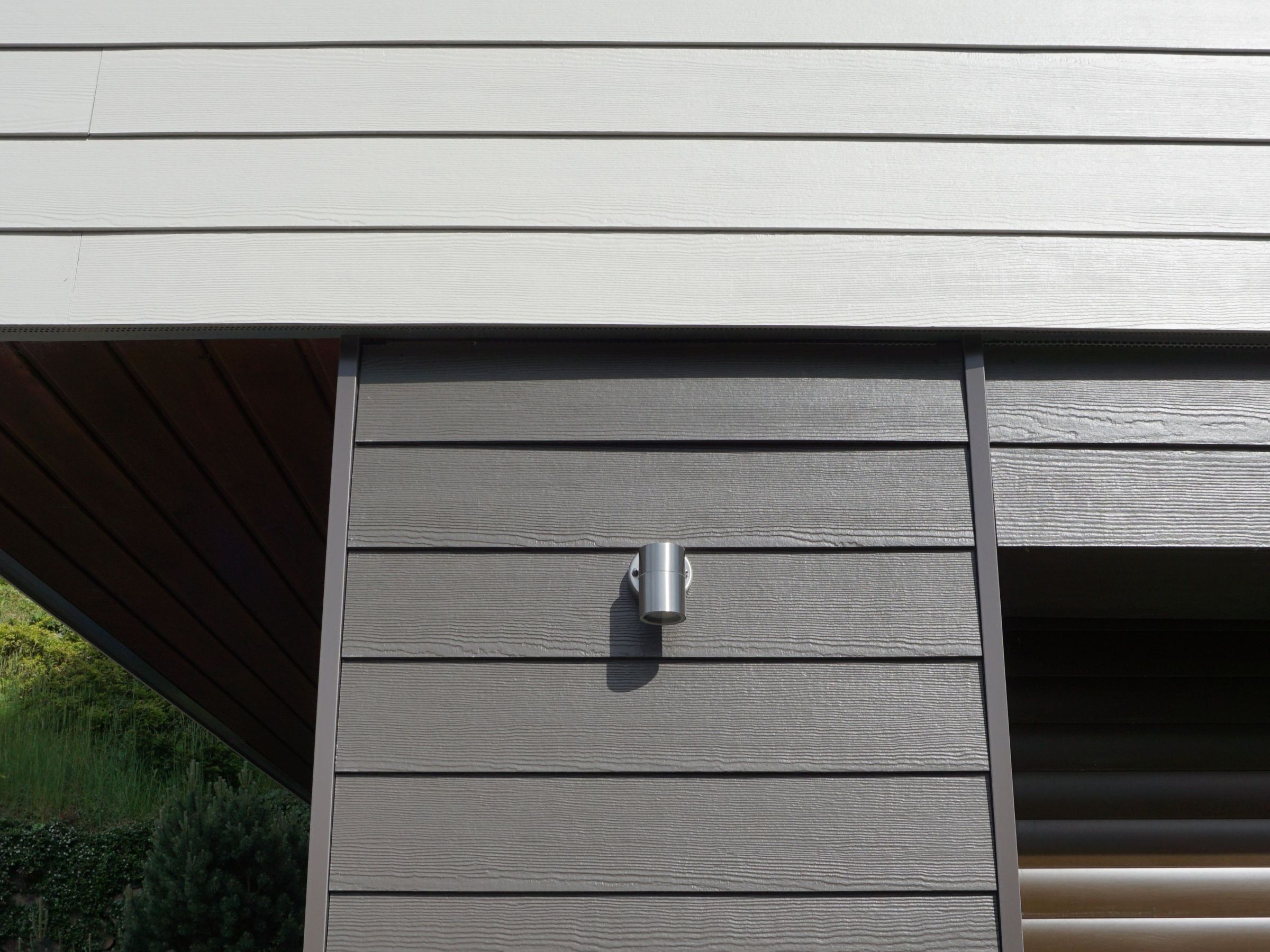 Waagerechte Faserzementfassade in kieselgrau am Holz-Anbau