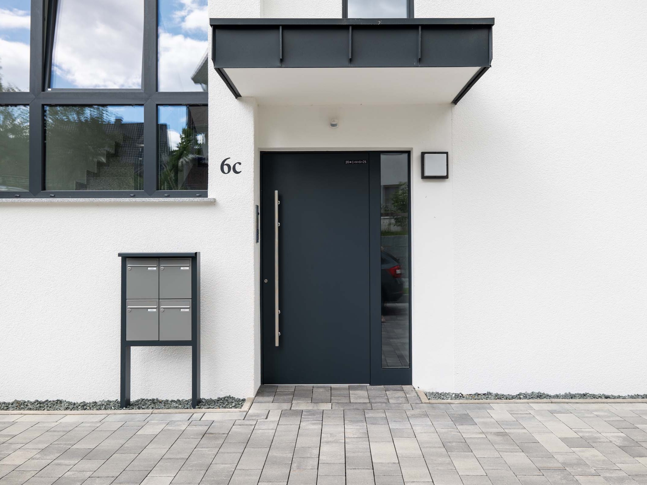 Haustür mit Seitenteilverglasung unter auskragendem Vordach