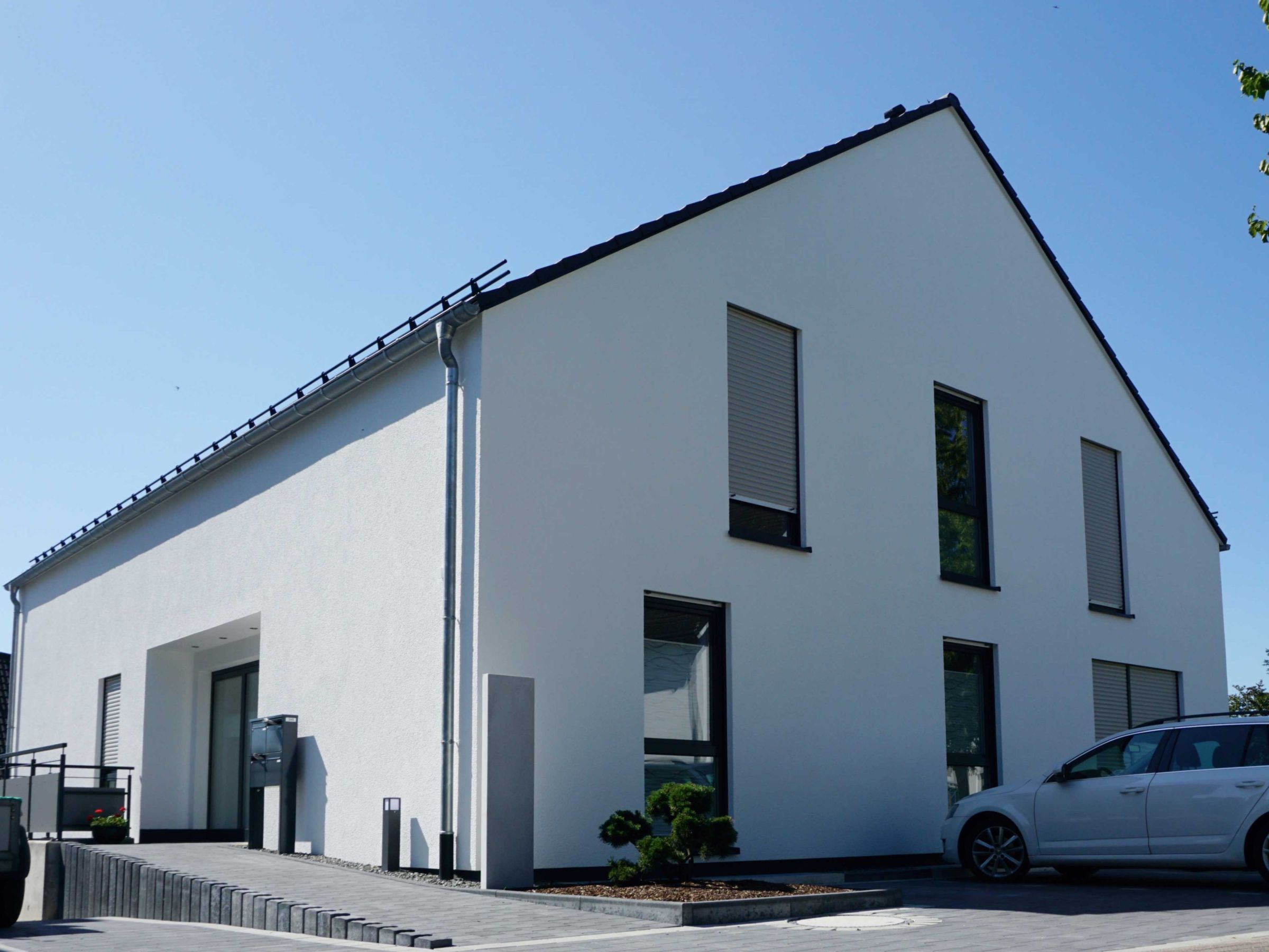 Straßenansicht eines Mehrfamilienhauses in Holzrahmenbauweise mit Satteldach