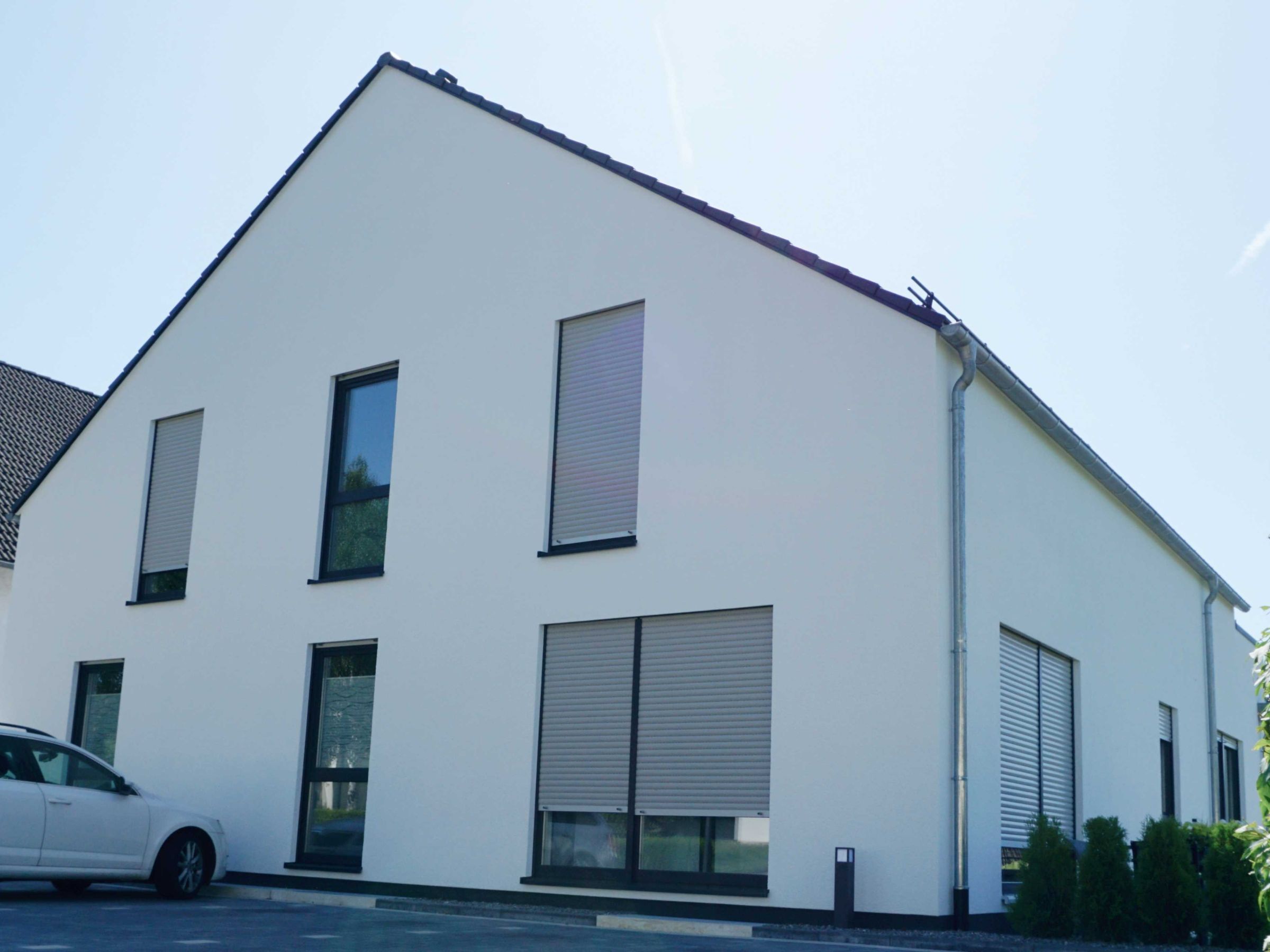 Fassadenecke eines Mehrfamilienhauses mit Putzoberfläche und Fensteröffnungen