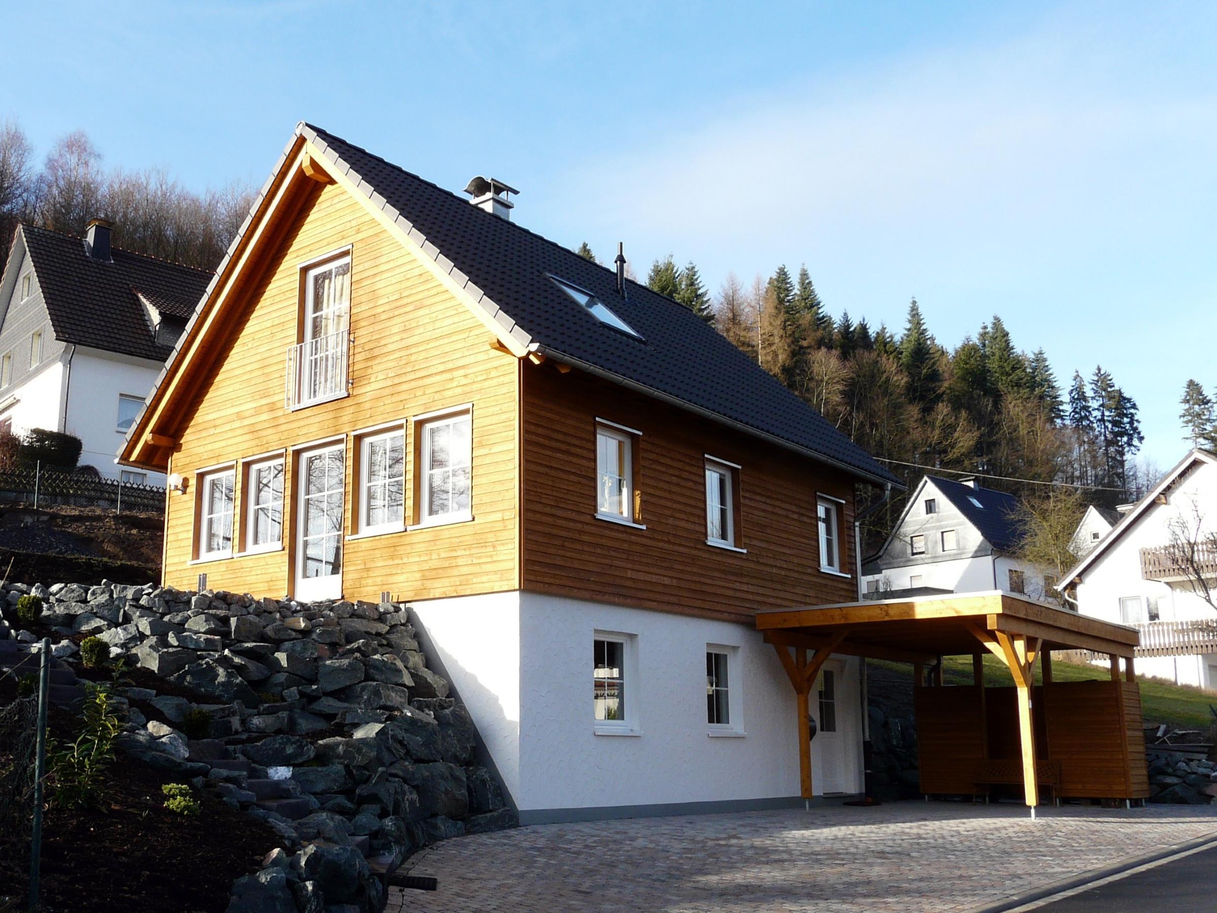 Holzhaus mit vorgelagertem Carport und Holzstützen