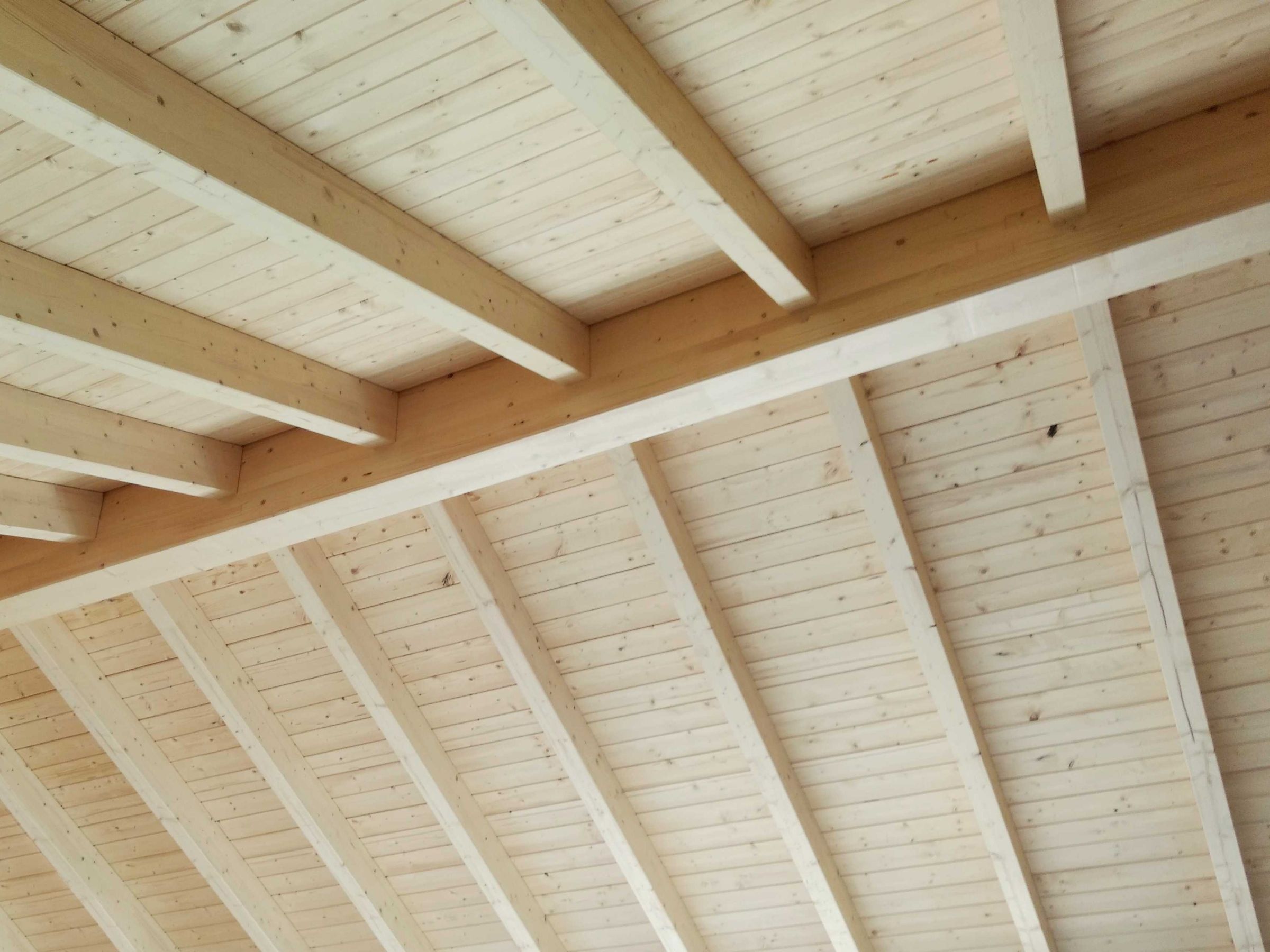 Offener Dachstuhl mit sichtbarer Holzbalkenkonstruktion und Holzschalung im Innenraum