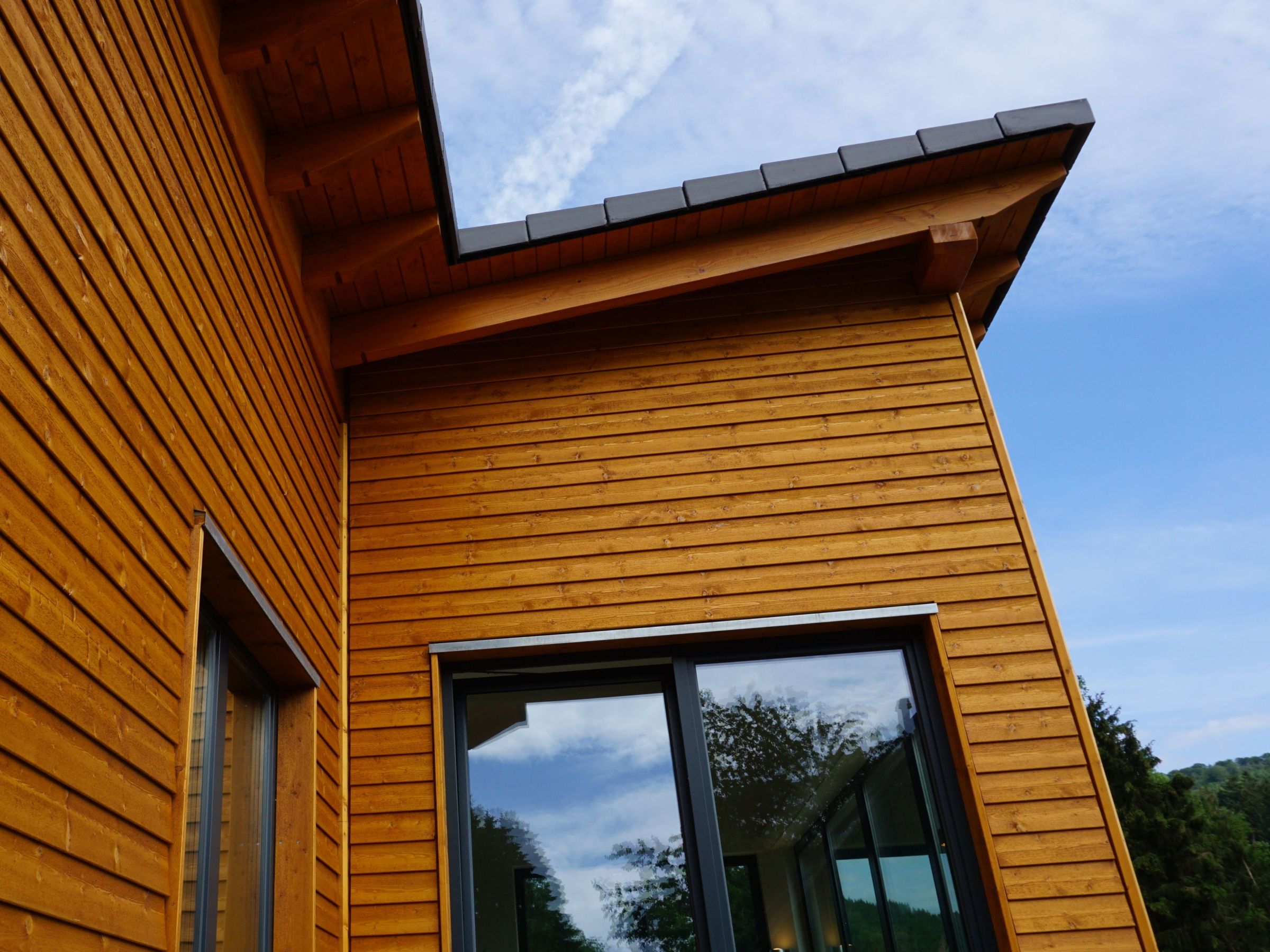 Detail der Holzfassade mit sichtbarem Dachüberstand und Holzunterkonstruktion