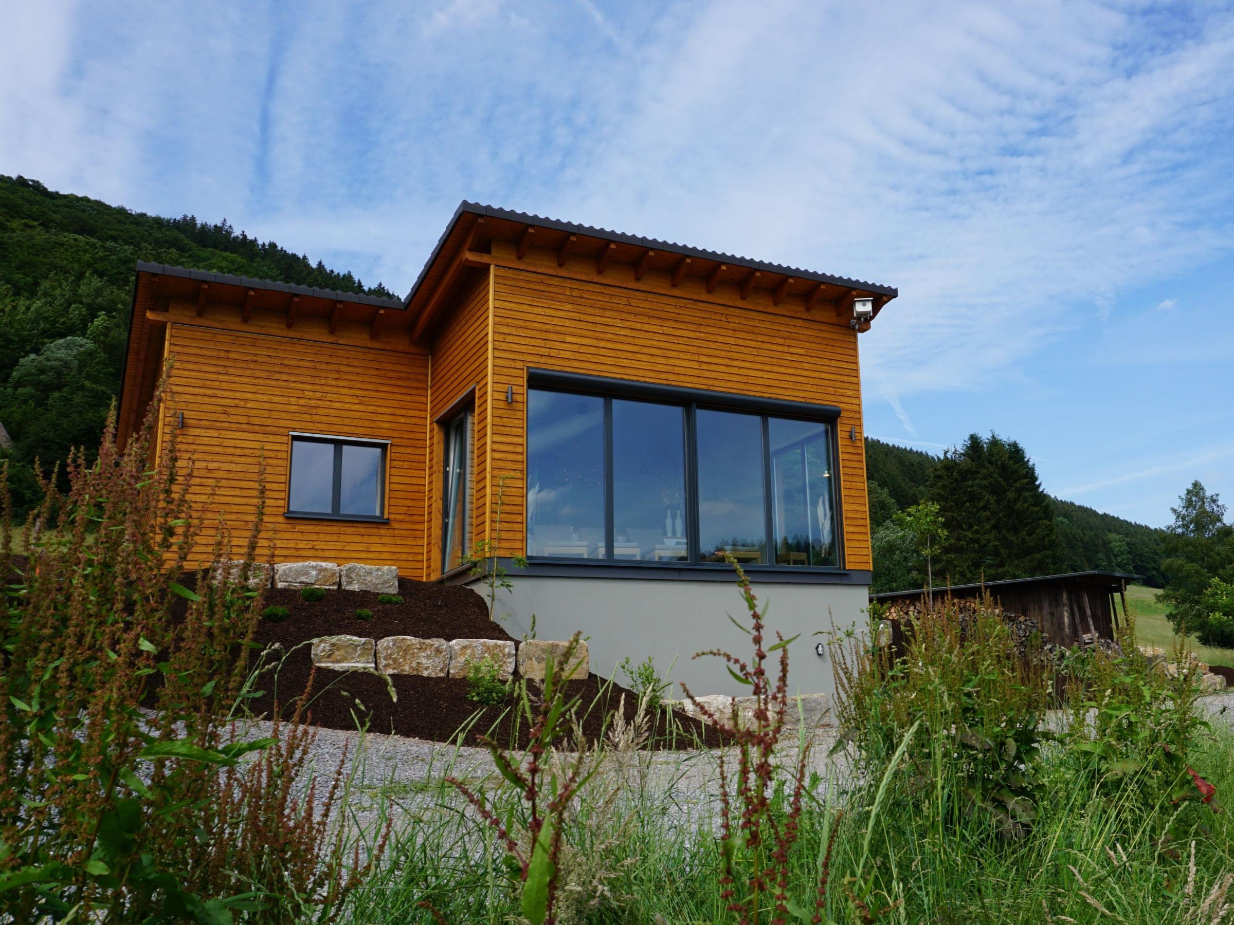 Saunahaus in Holzbauweise eingebettet in eine offene Naturlandschaft