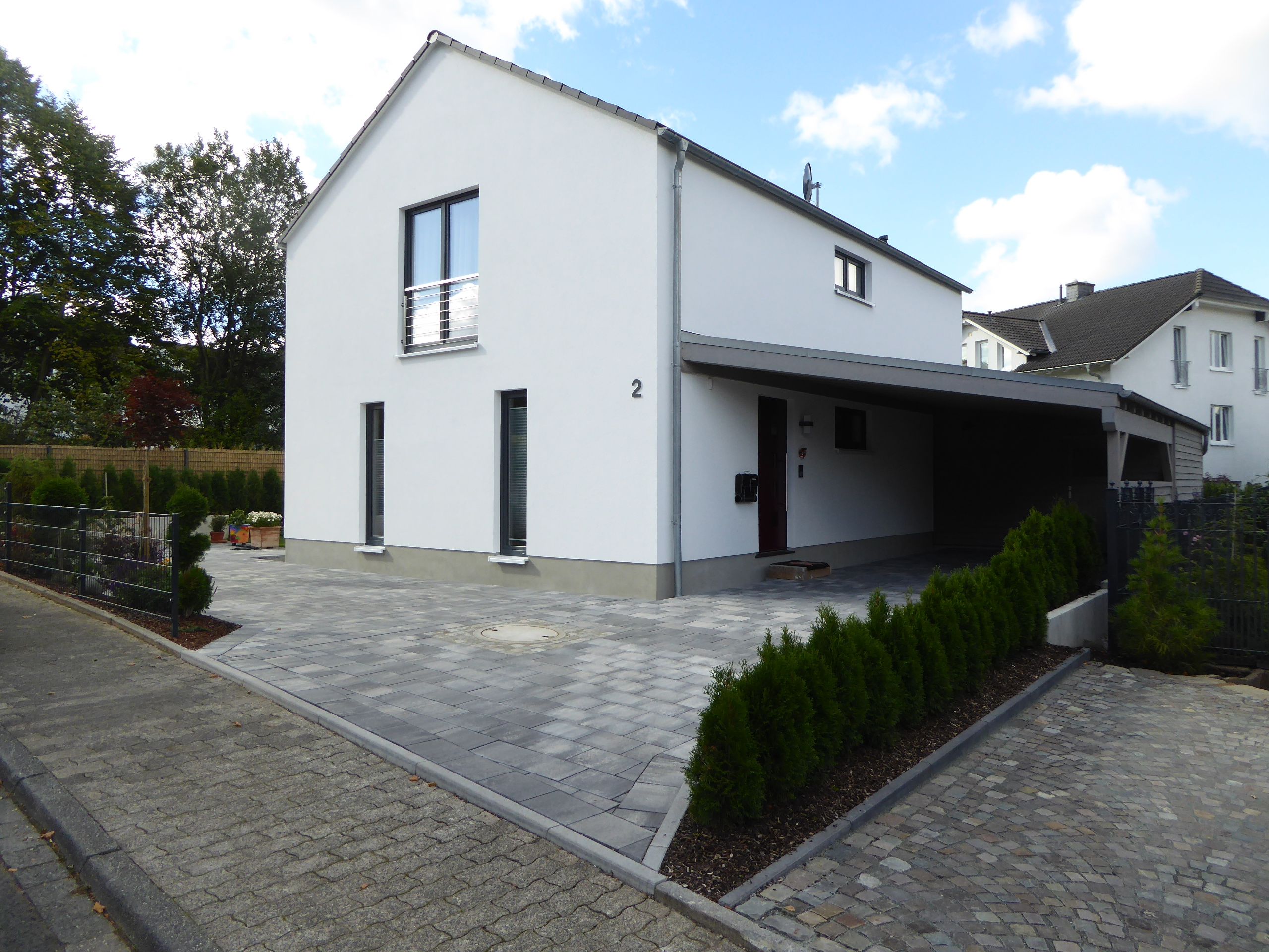 Eingangsbereich mit überdachtem Carport und klarer Kubusform