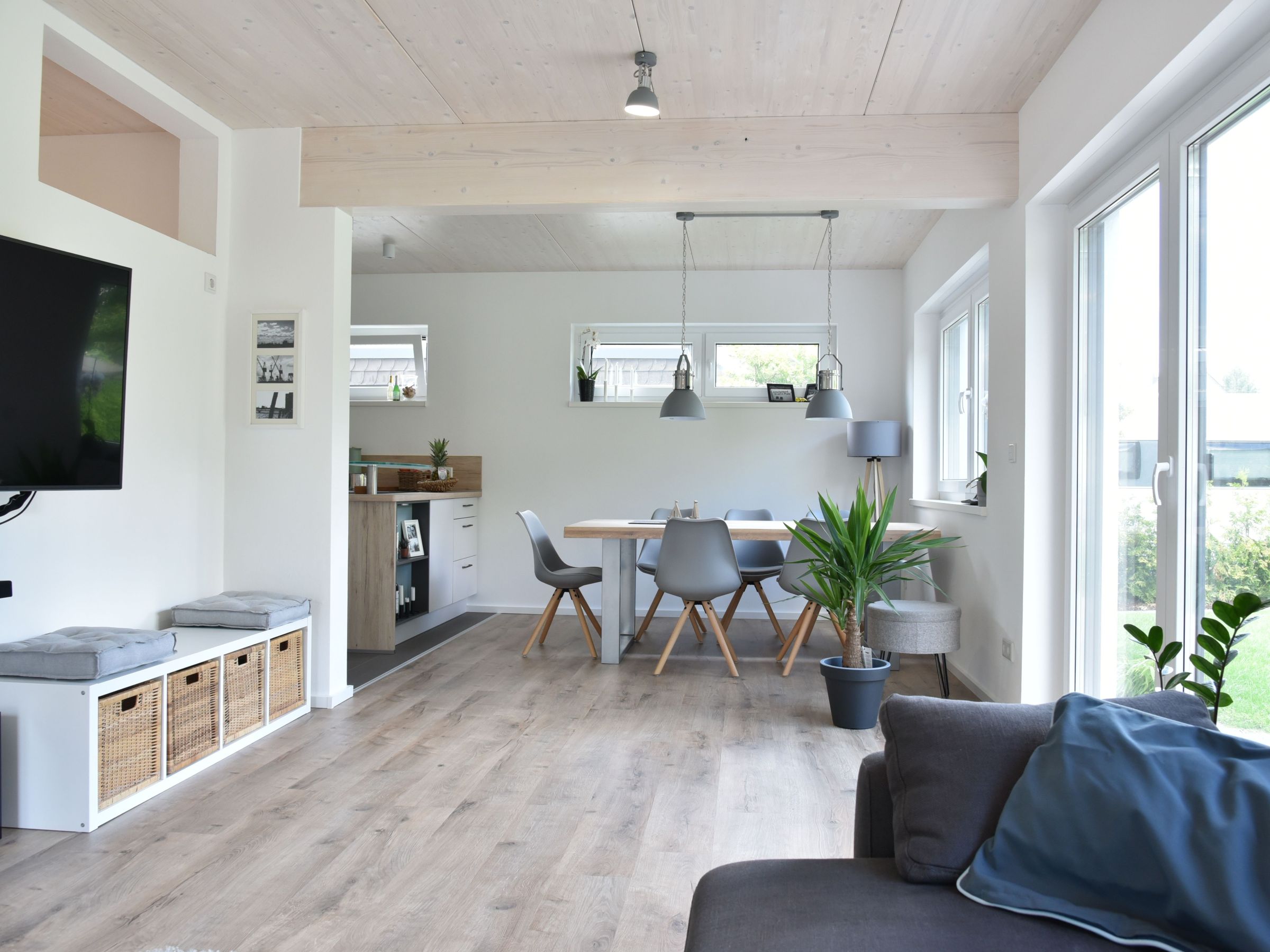 Heller Wohnbereich mit offener Raumstruktur, Essplatz und sichtbarer Holzdecke