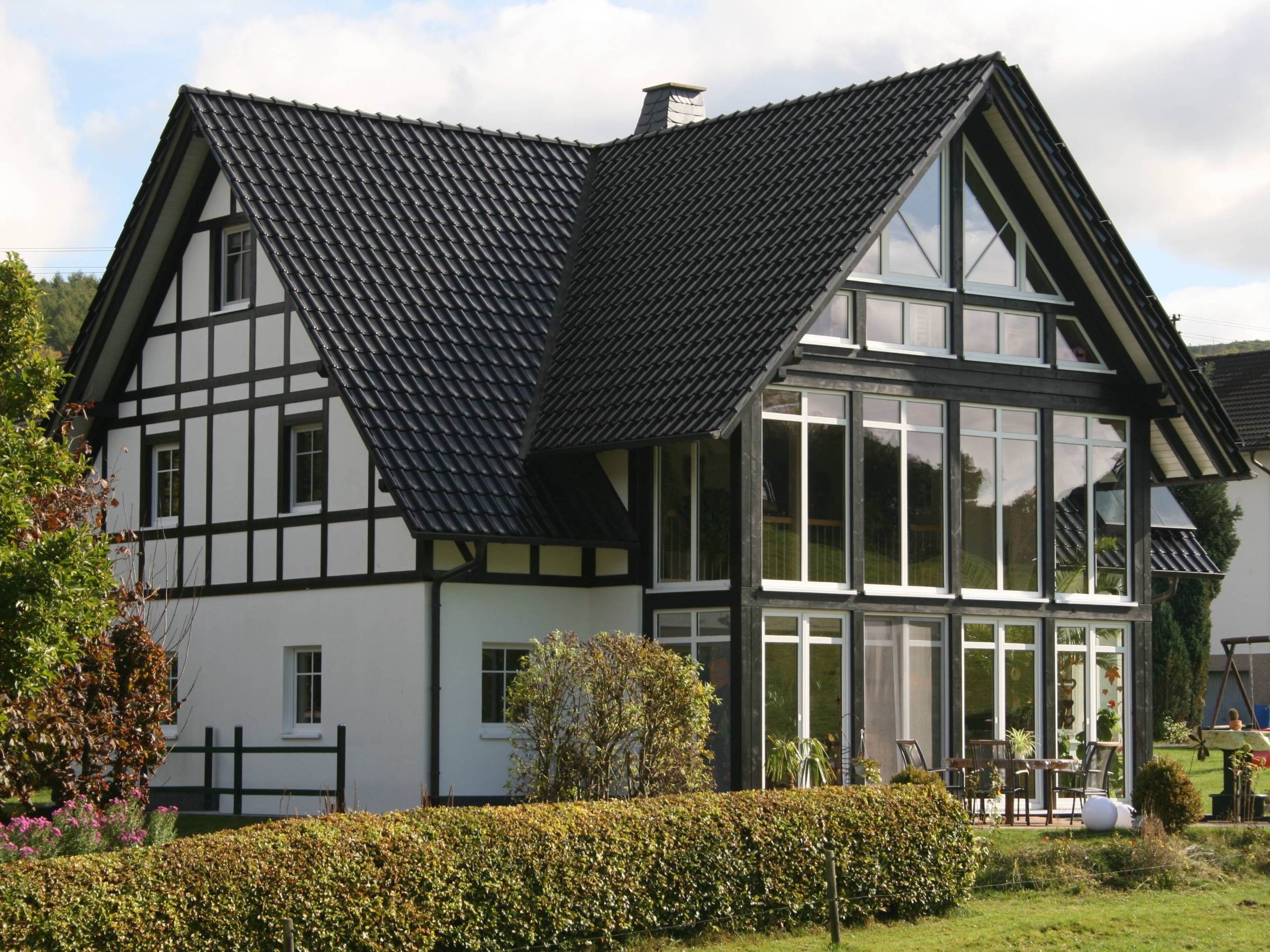 Rückansicht eines Viergiebelhauses mit mehrgeschossigem Wintergarten