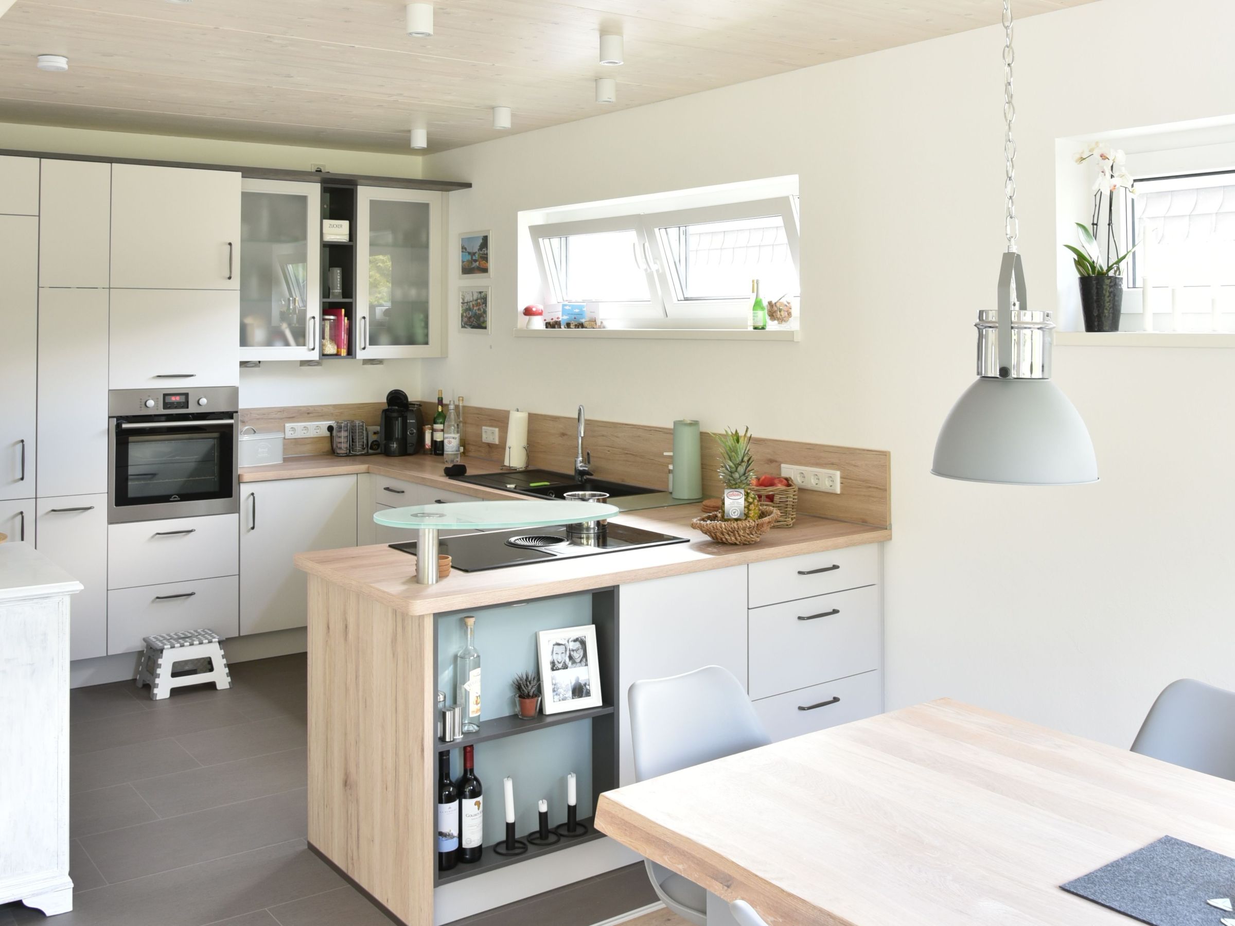 Moderne Küche mit Kochinsel, Holzarbeitsflächen und Massivholzdecke