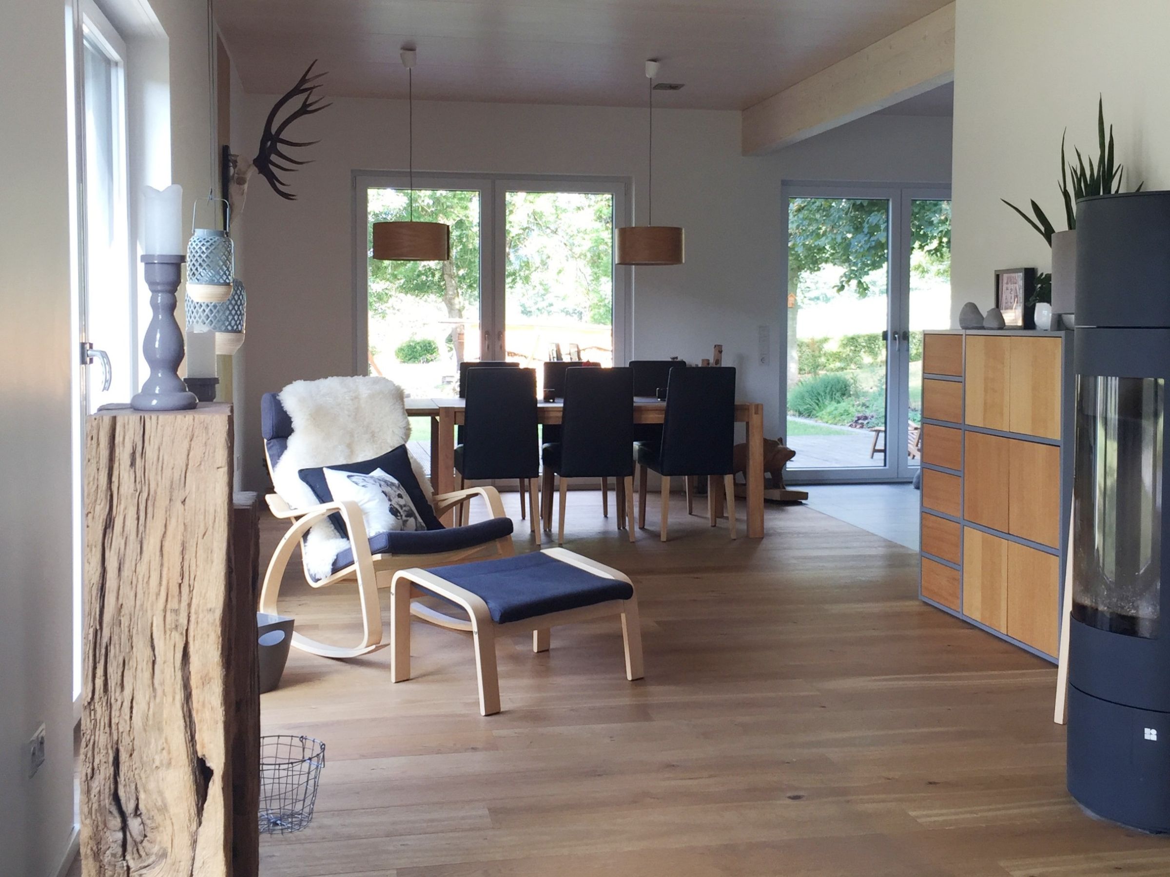 Offener Wohn- und Essbereich mit sichtbarer Massivholzdecke und bodentiefen Fenstern